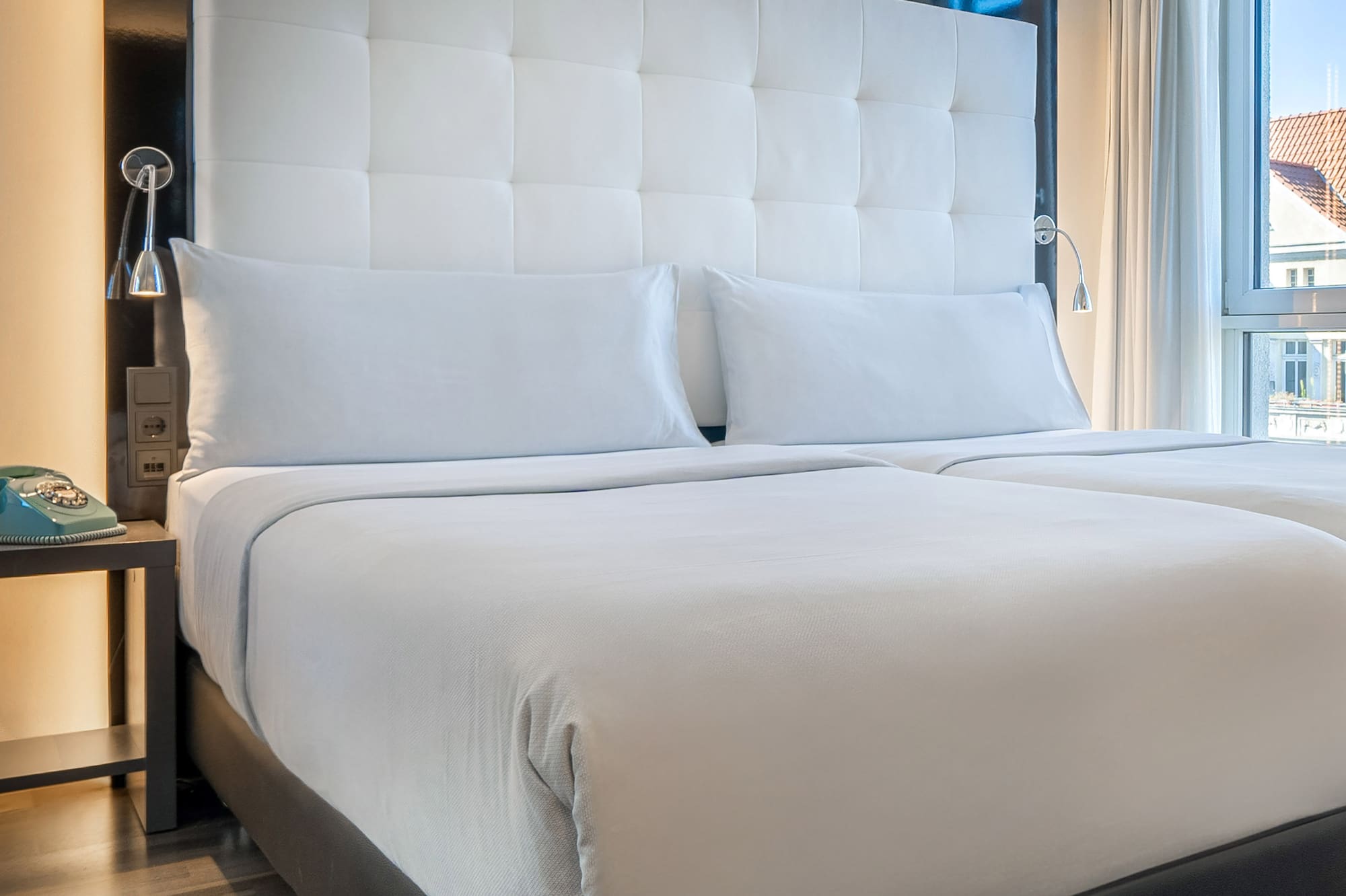 a bed with white sheets and a black headboard