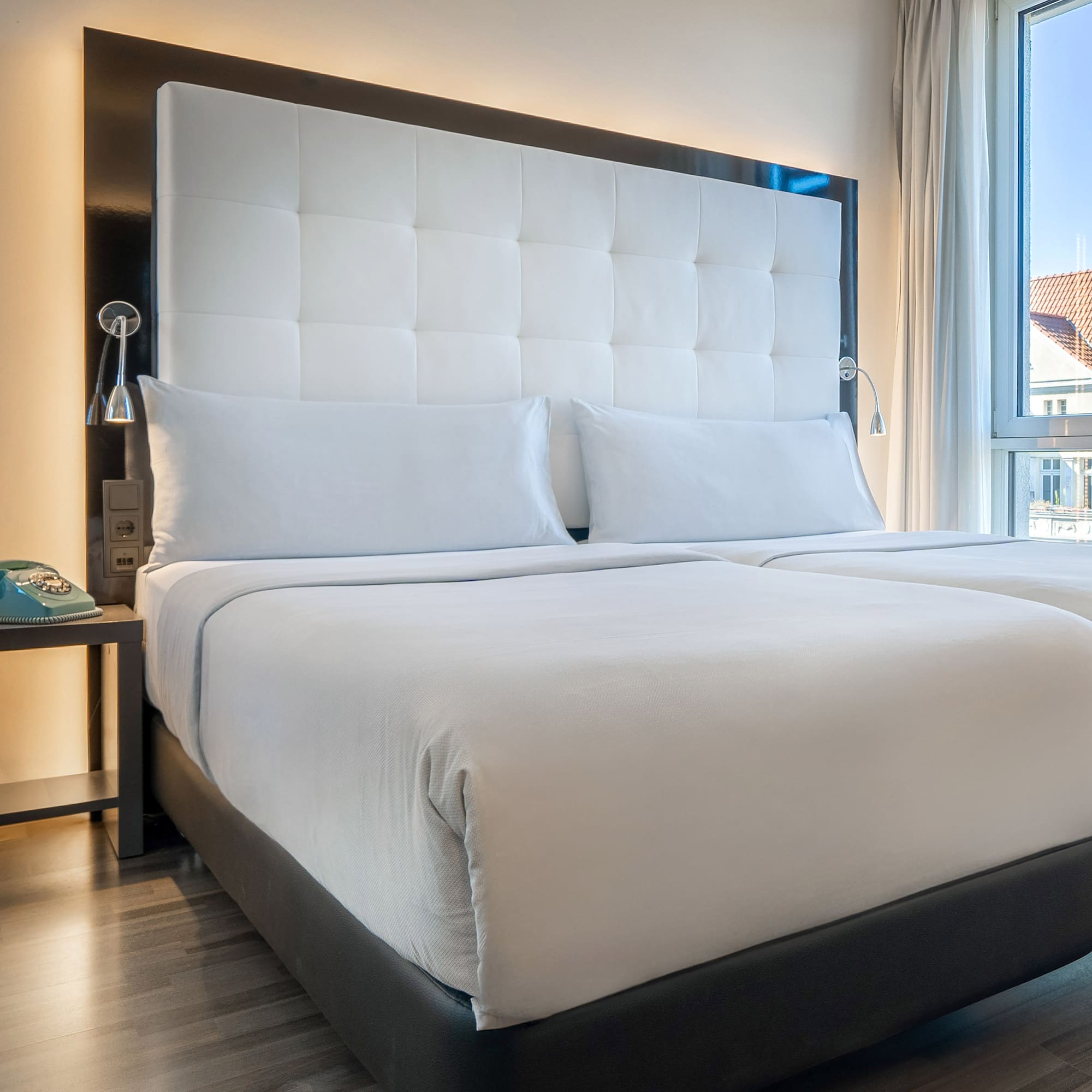 a bed with white sheets and a black headboard