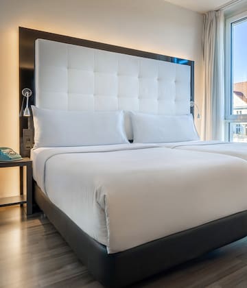 a bed with white sheets and a black headboard