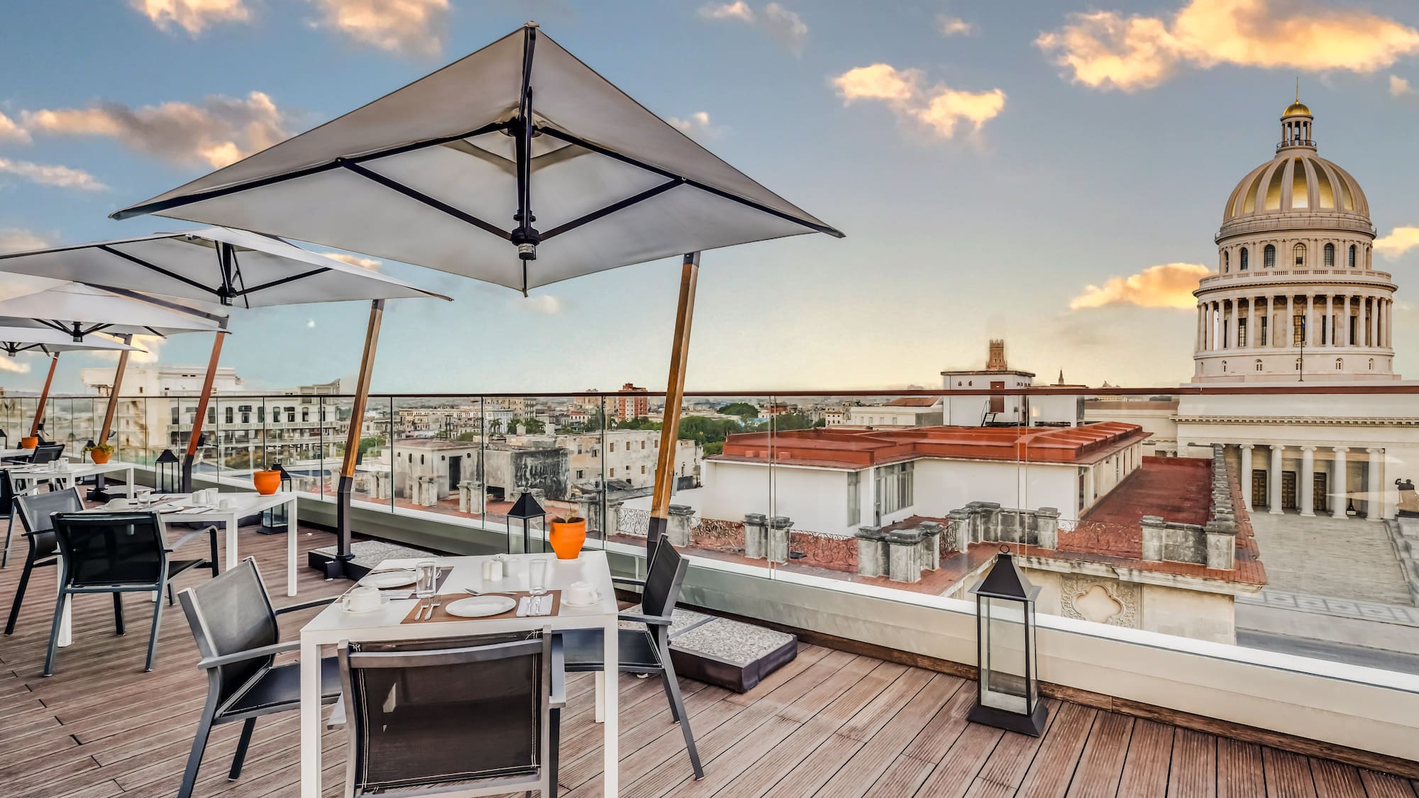 a table and chairs on a deck with a large umbrella