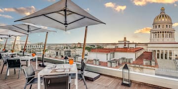 a table and chairs on a deck with a large umbrella