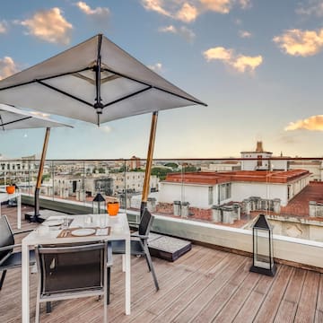 a table and chairs on a deck with a large umbrella