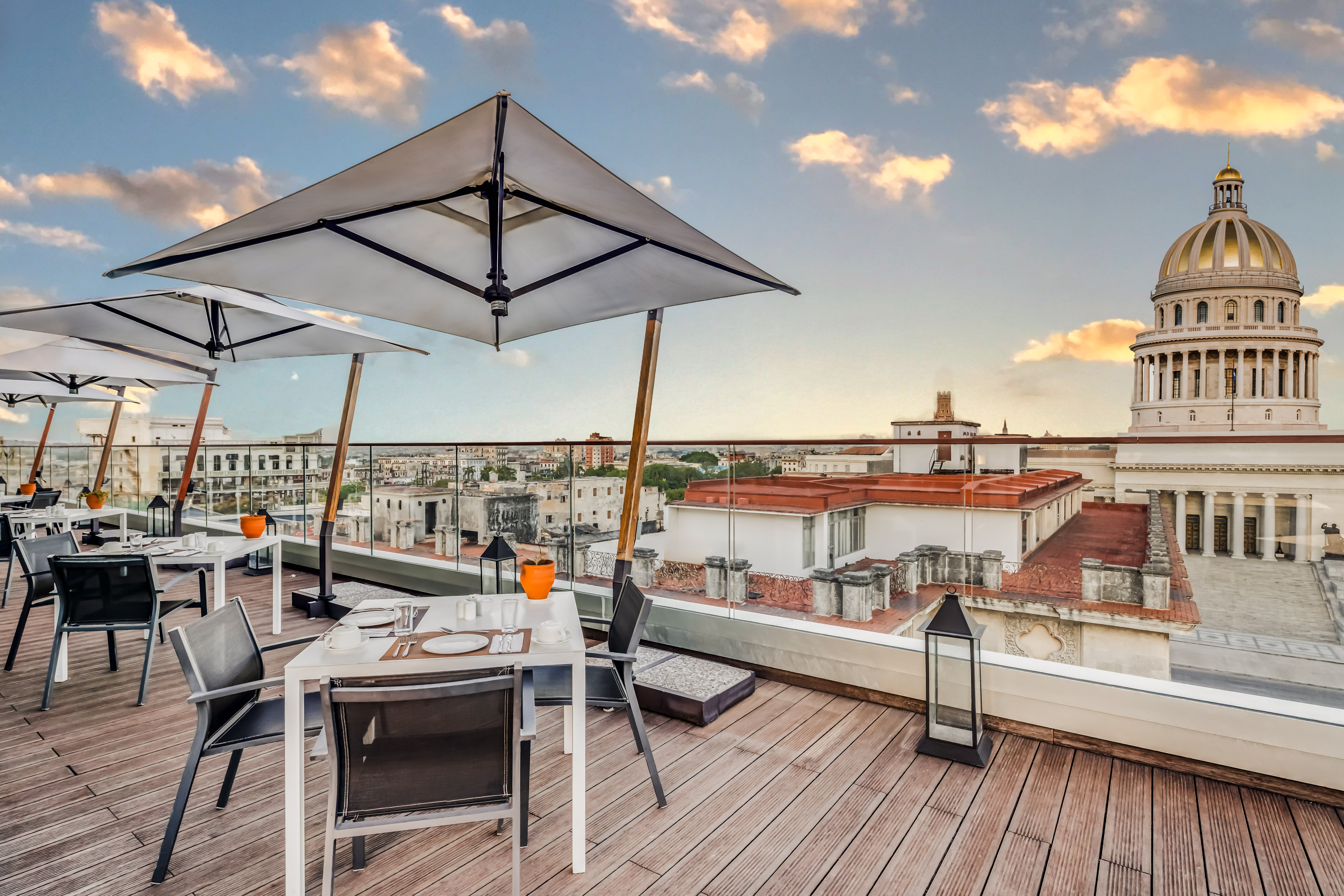 a table and chairs on a deck with a large umbrella