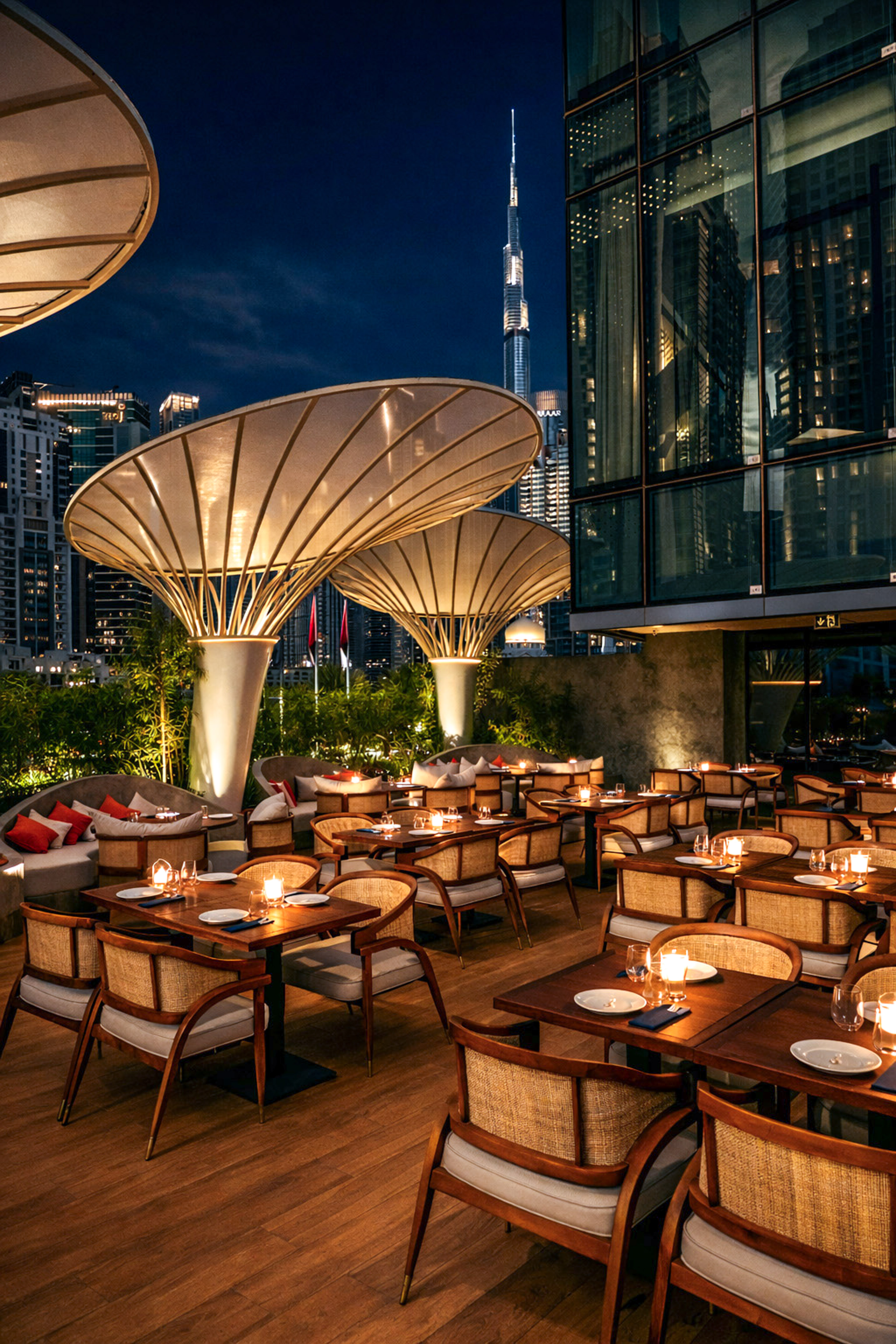 Dubai outdoor restaurant with Burj Khalifa view at night, candlelit tables.