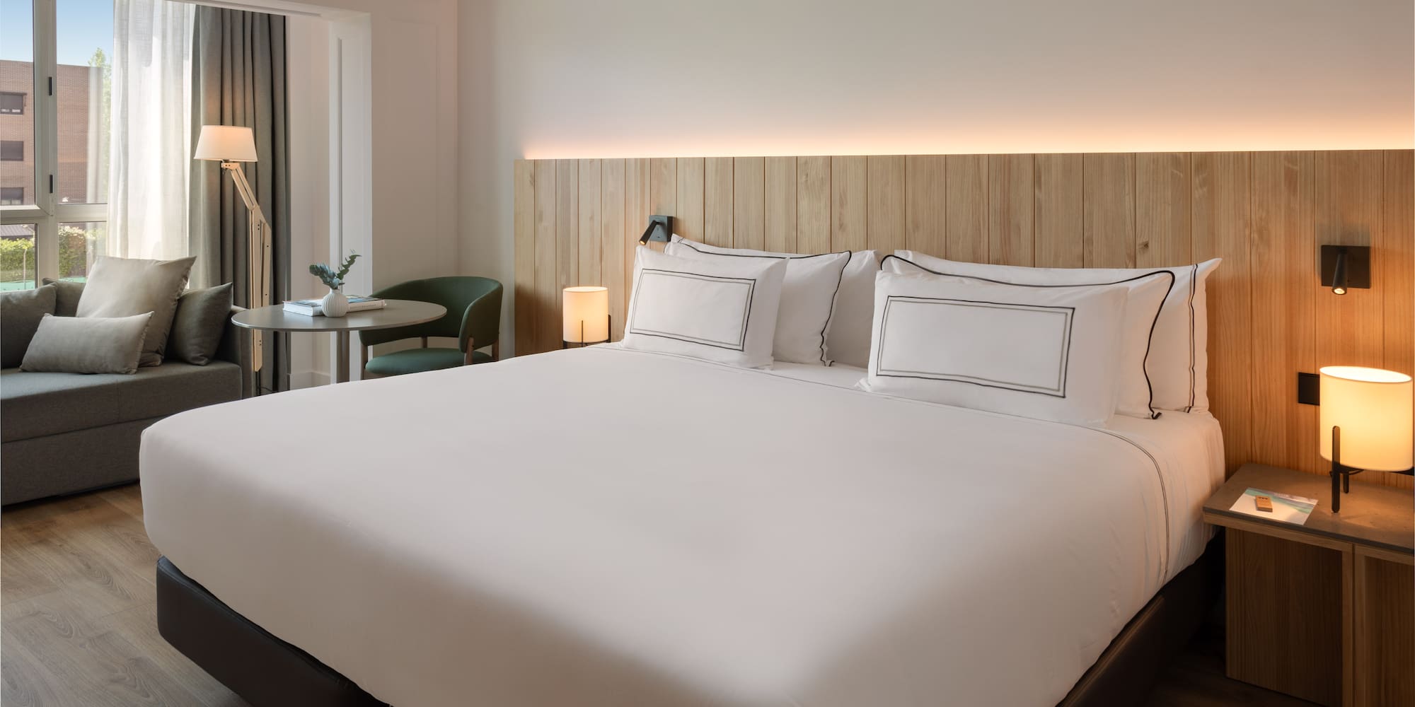 a bed with white sheets and a table in a room