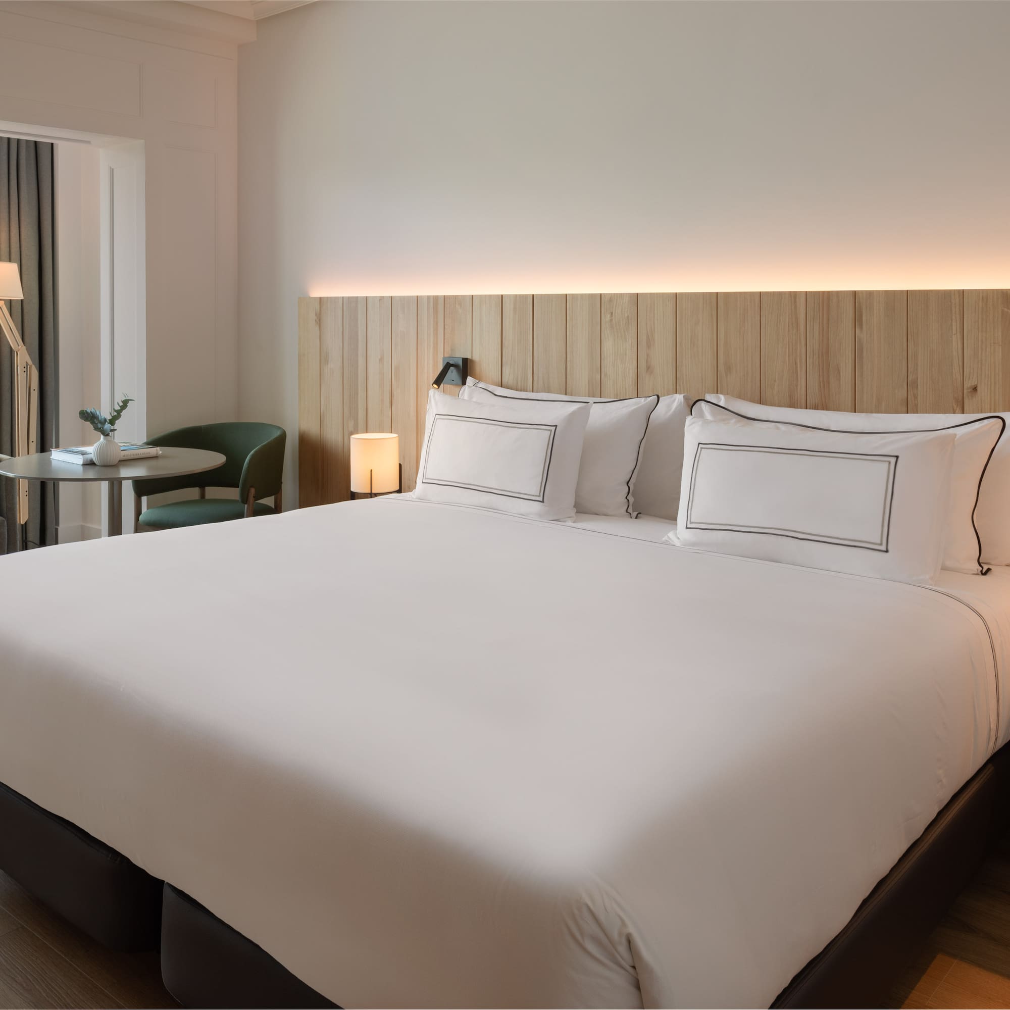 a bed with white sheets and a table in a room