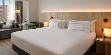 a bed with white sheets and a table in a room