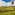 Vibrant rainbow hot air balloon above lush green vineyards and hills.