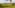 Rainbow hot air balloon over lush Italian vineyards and rolling hills.