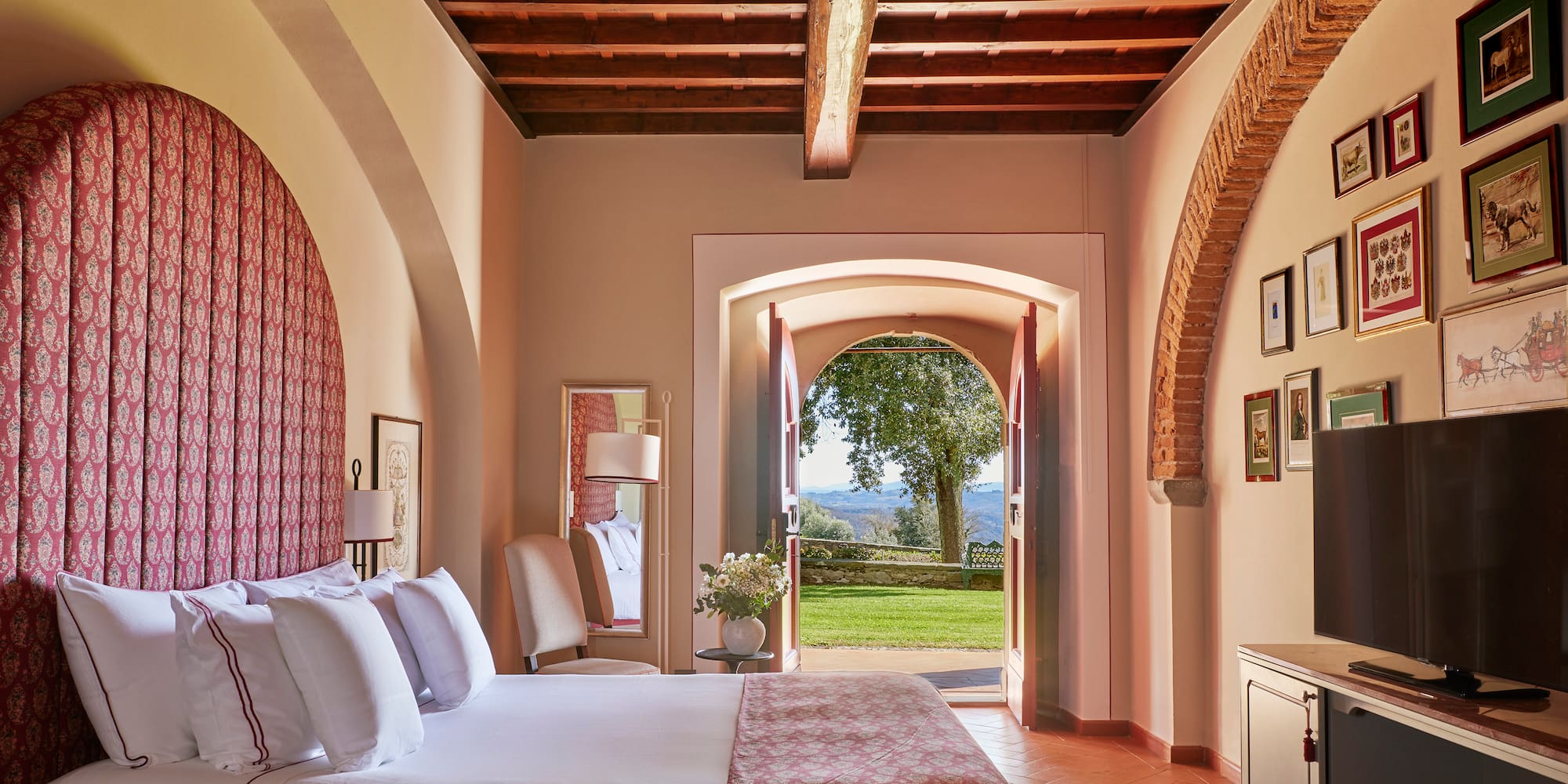 a bedroom with a bed and a door open to a lawn