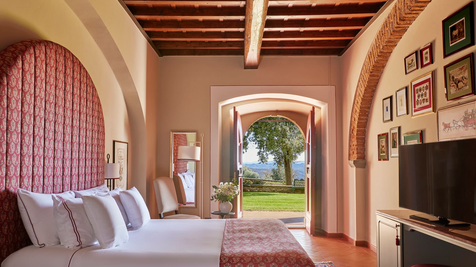 a bedroom with a bed and a door open to a lawn