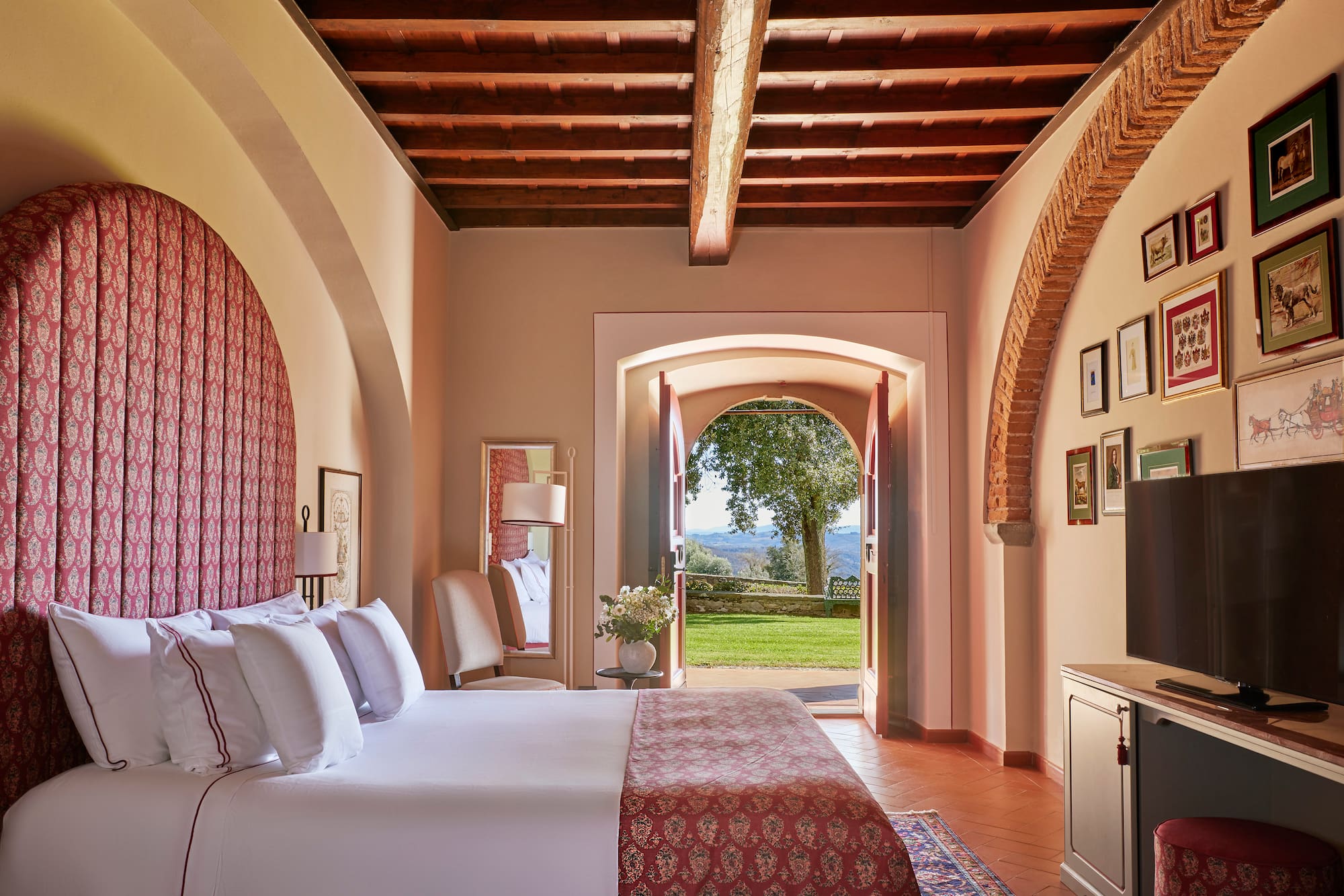 a bedroom with a bed and a door open to a lawn