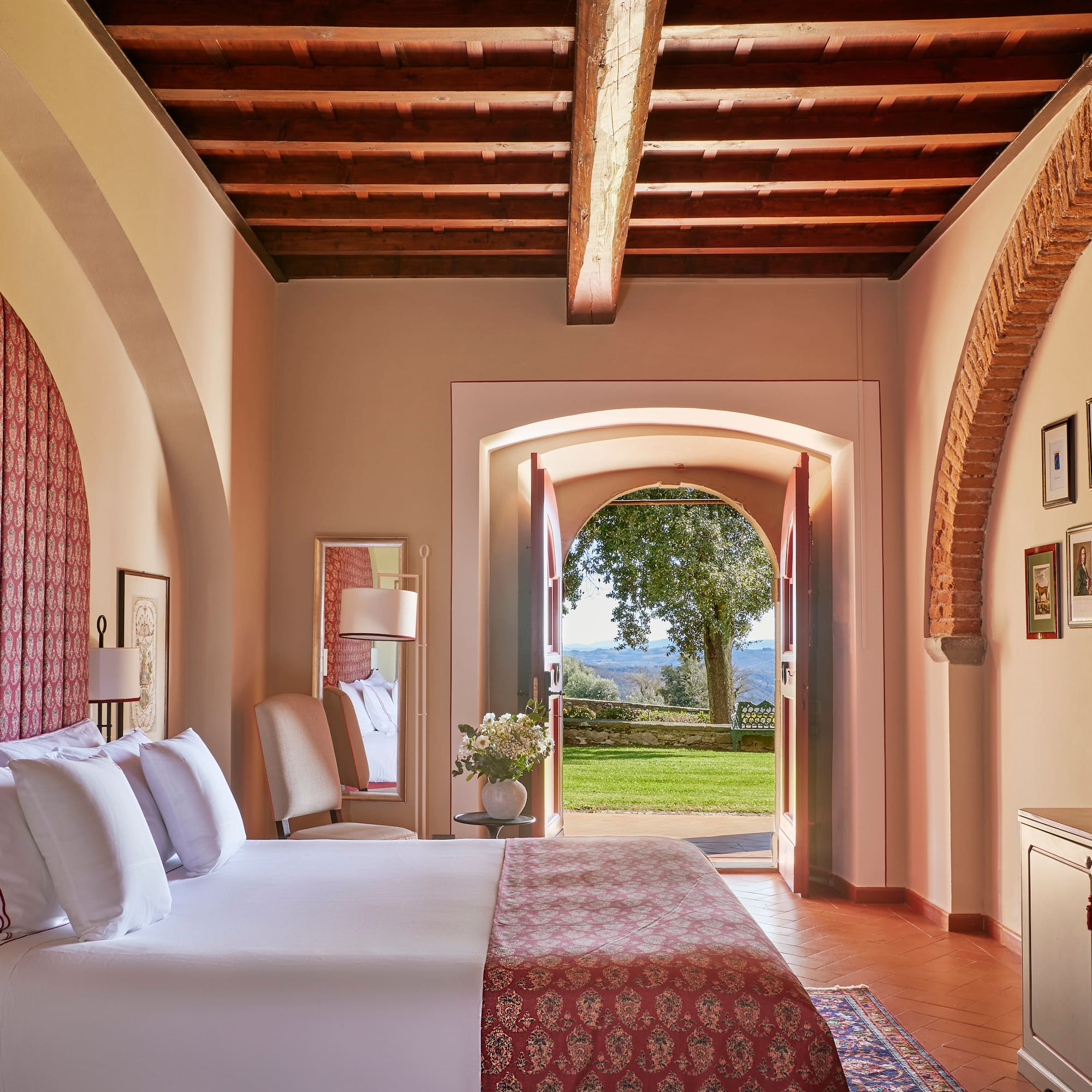 a bedroom with a bed and a door open to a lawn