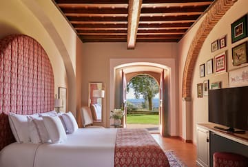 a bedroom with a bed and a door open to a lawn