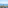 Balcony sea view of coastal buildings, distant mountains, and a tall pine tree.