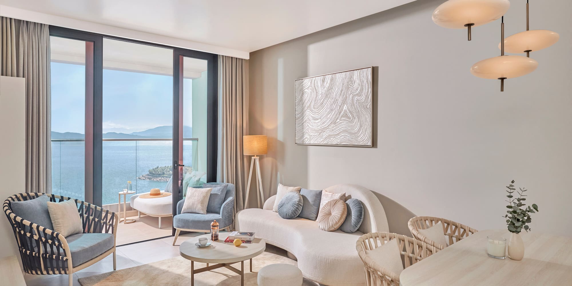 Stylish ocean view living room with balcony and modern furniture.