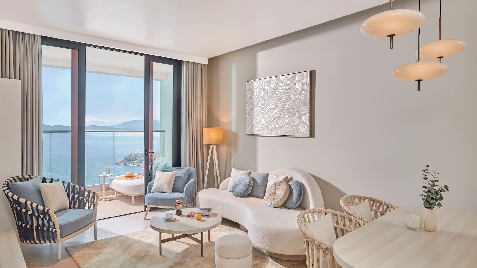 Stylish ocean view living room with balcony and modern furniture.