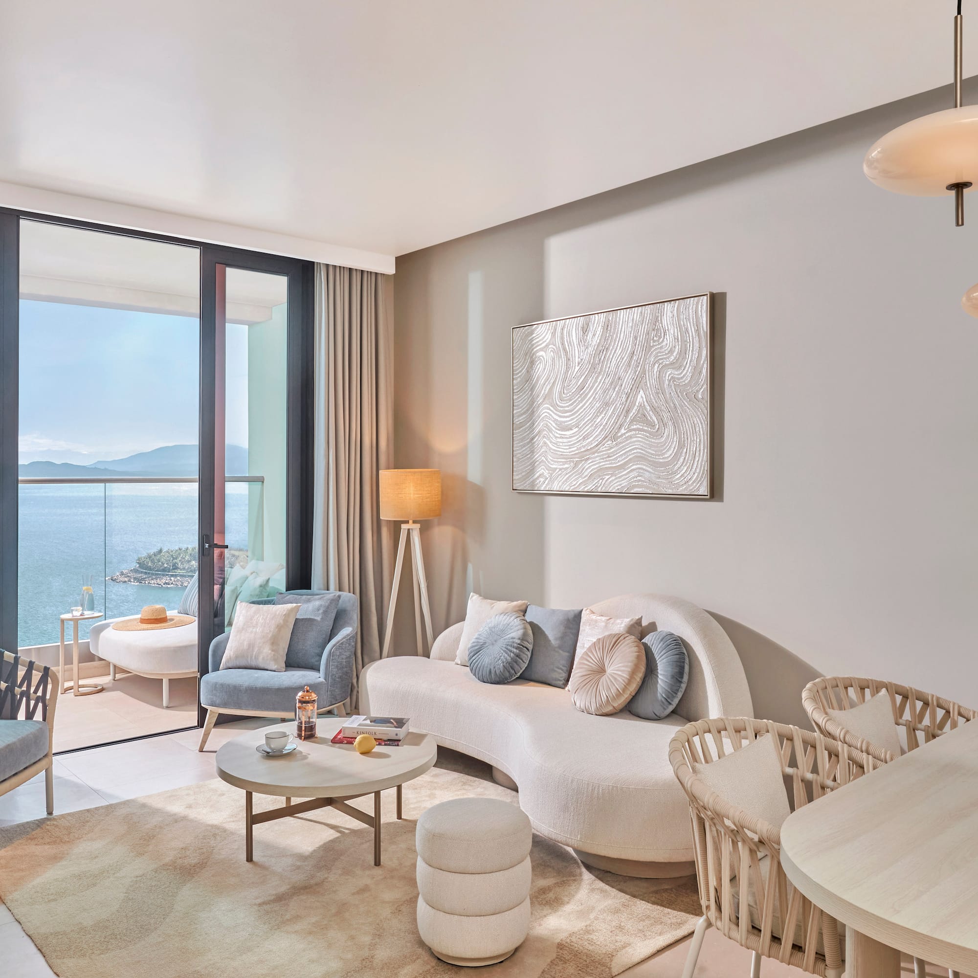 Stylish ocean view living room with balcony and modern furniture.