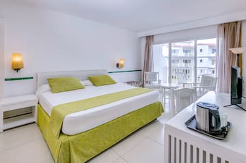 a room with a bed and a table and chairs