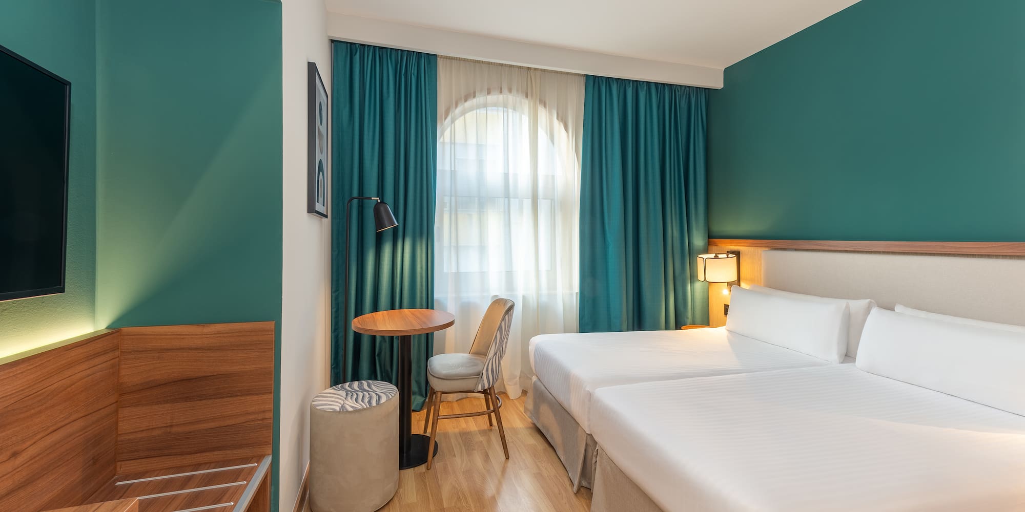 a room with two beds and a table and chair