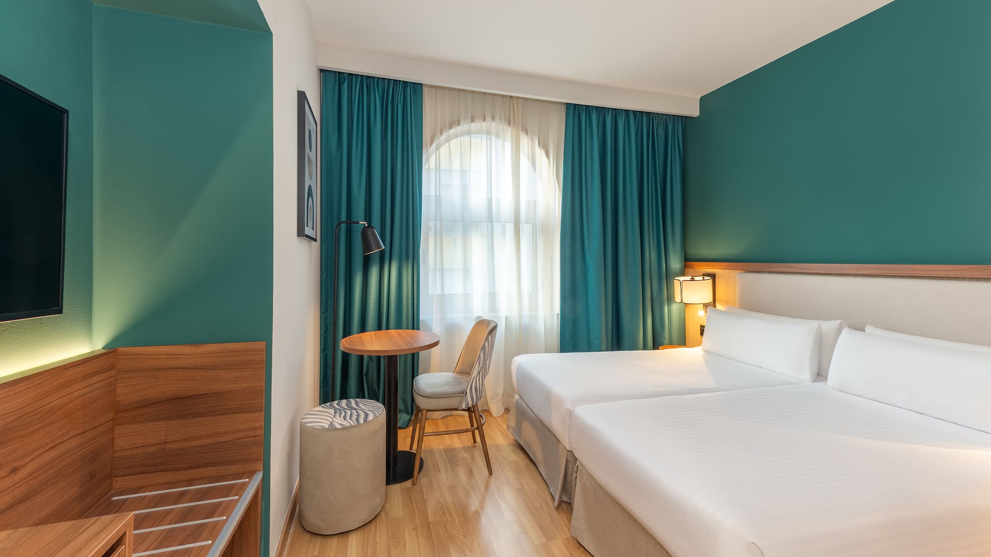 a room with two beds and a table and chair