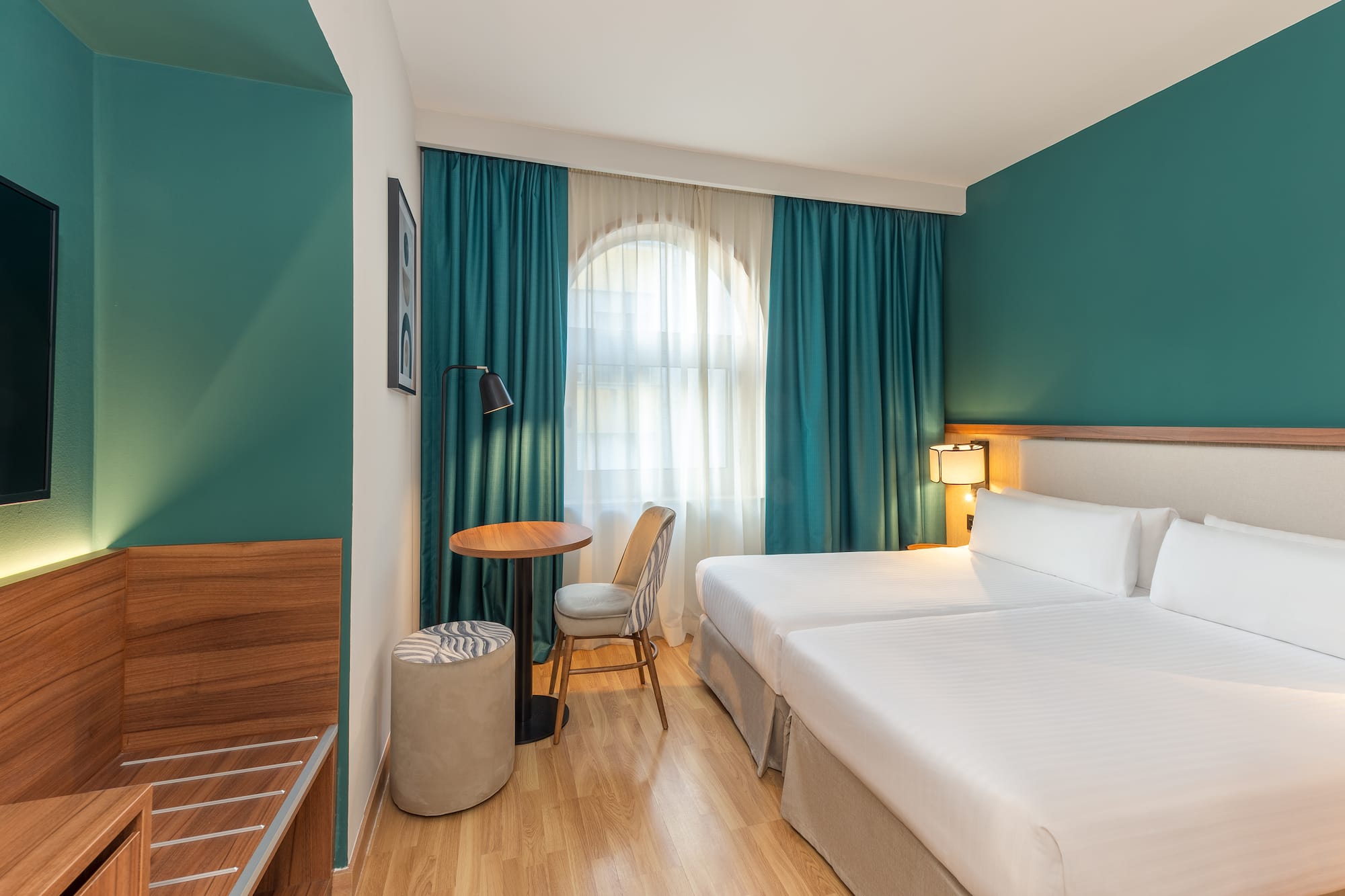 a room with two beds and a table and chair