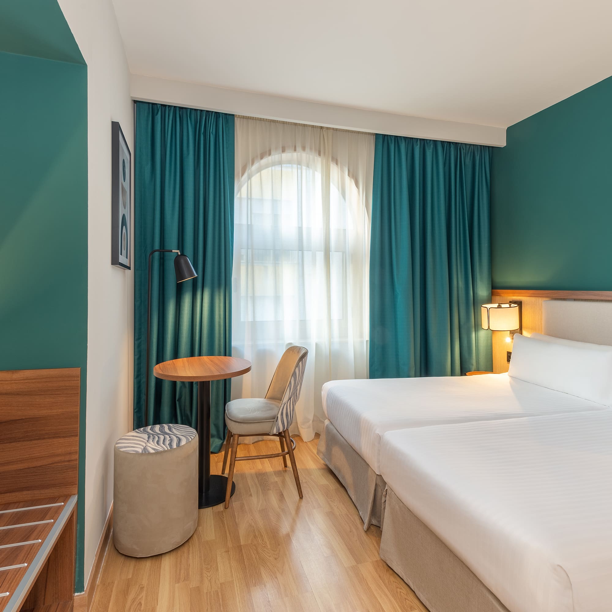 a room with two beds and a table and chair