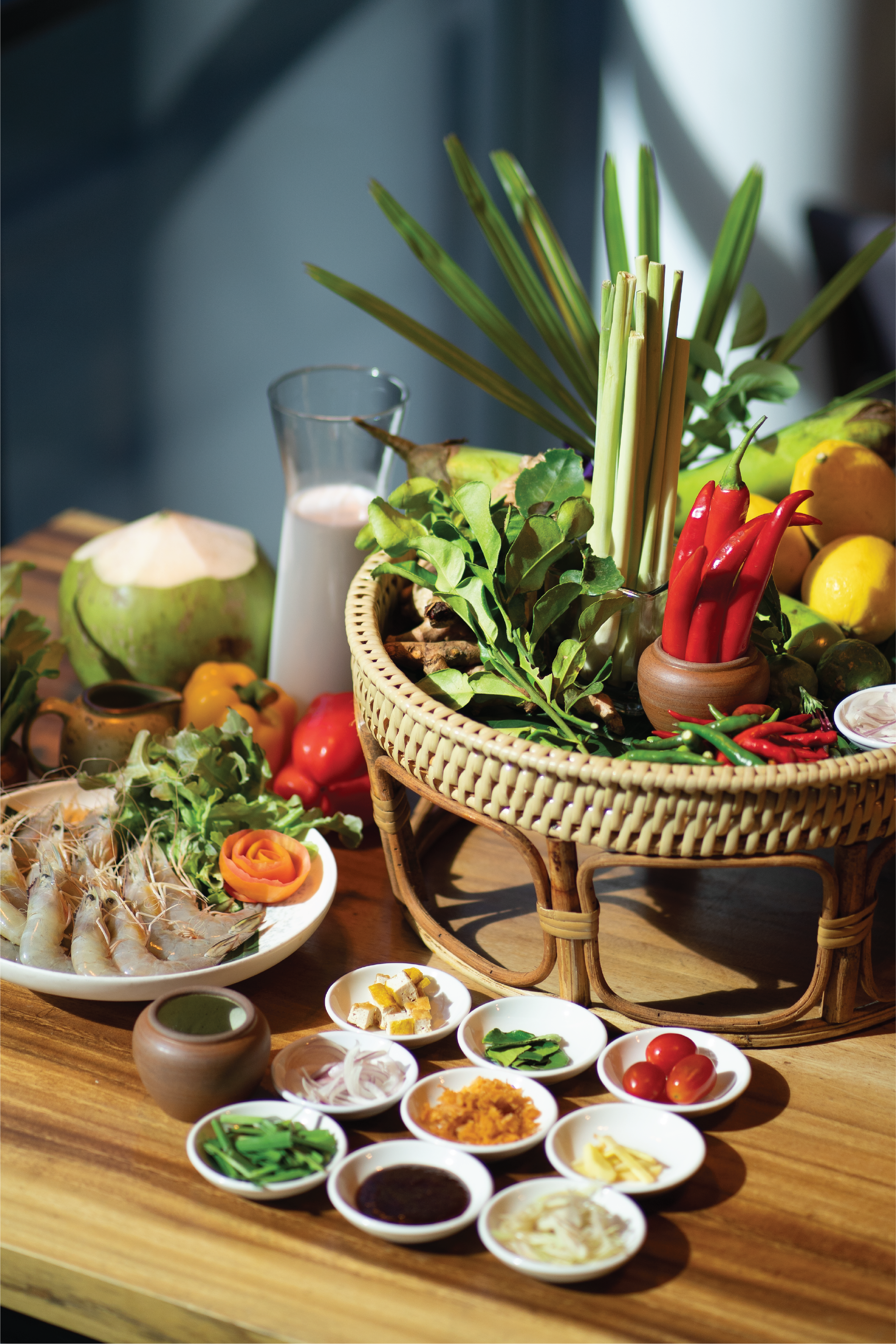 Fresh Thai cooking ingredients: shrimp, chilies, lemongrass, kaffir lime, coconut on wood.