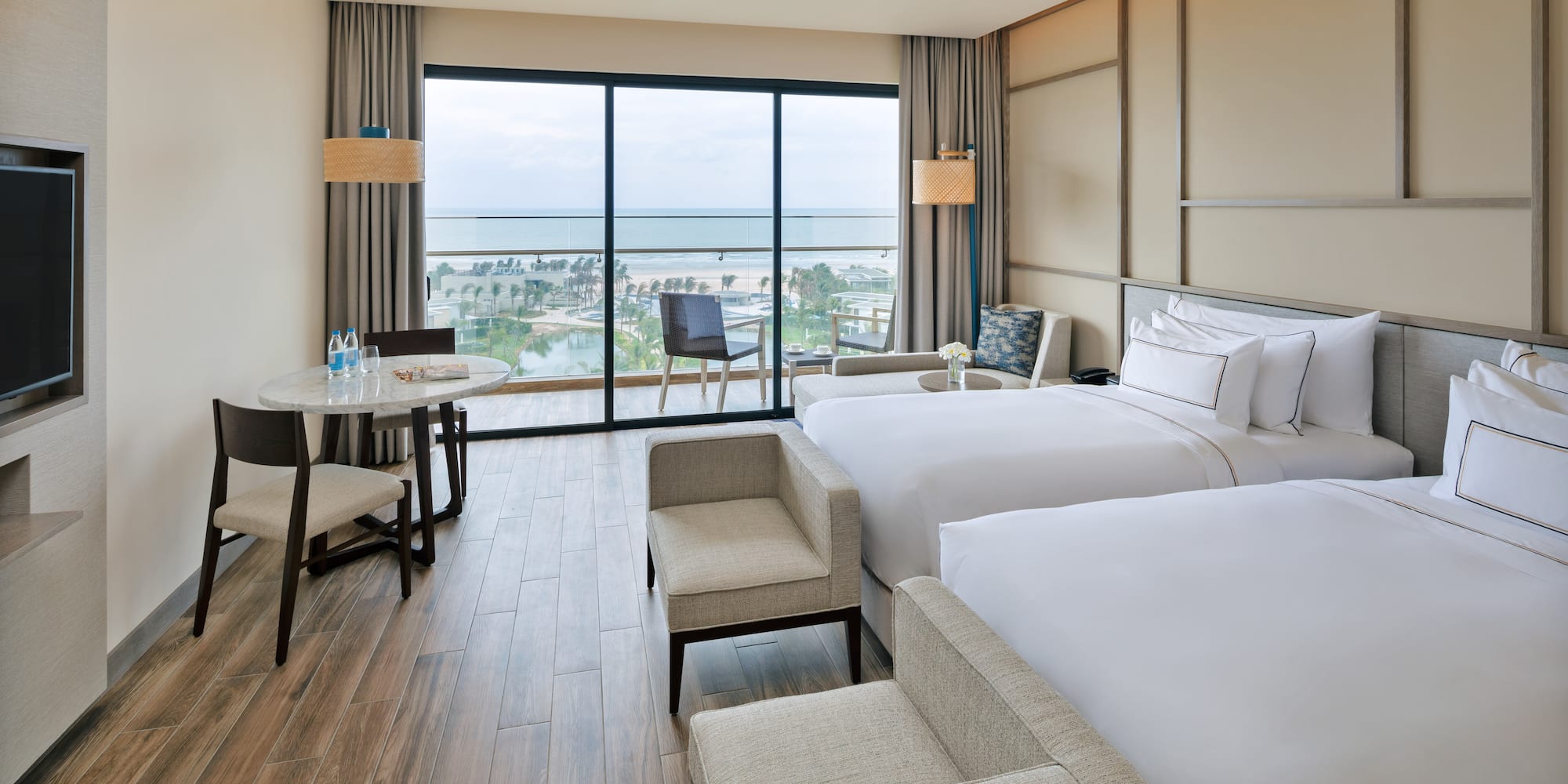 a room with two beds and a table and chairs