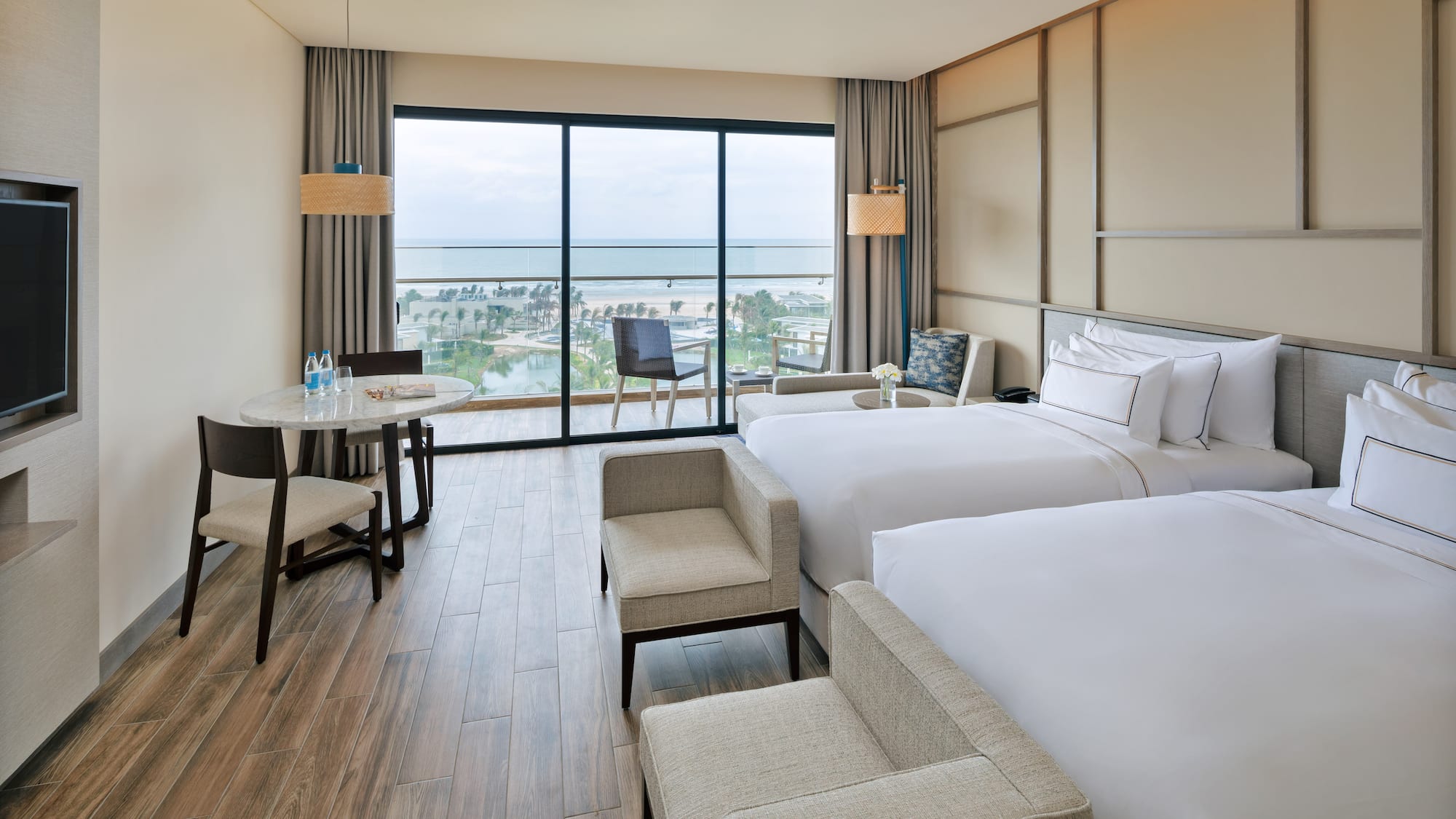 a room with two beds and a table and chairs