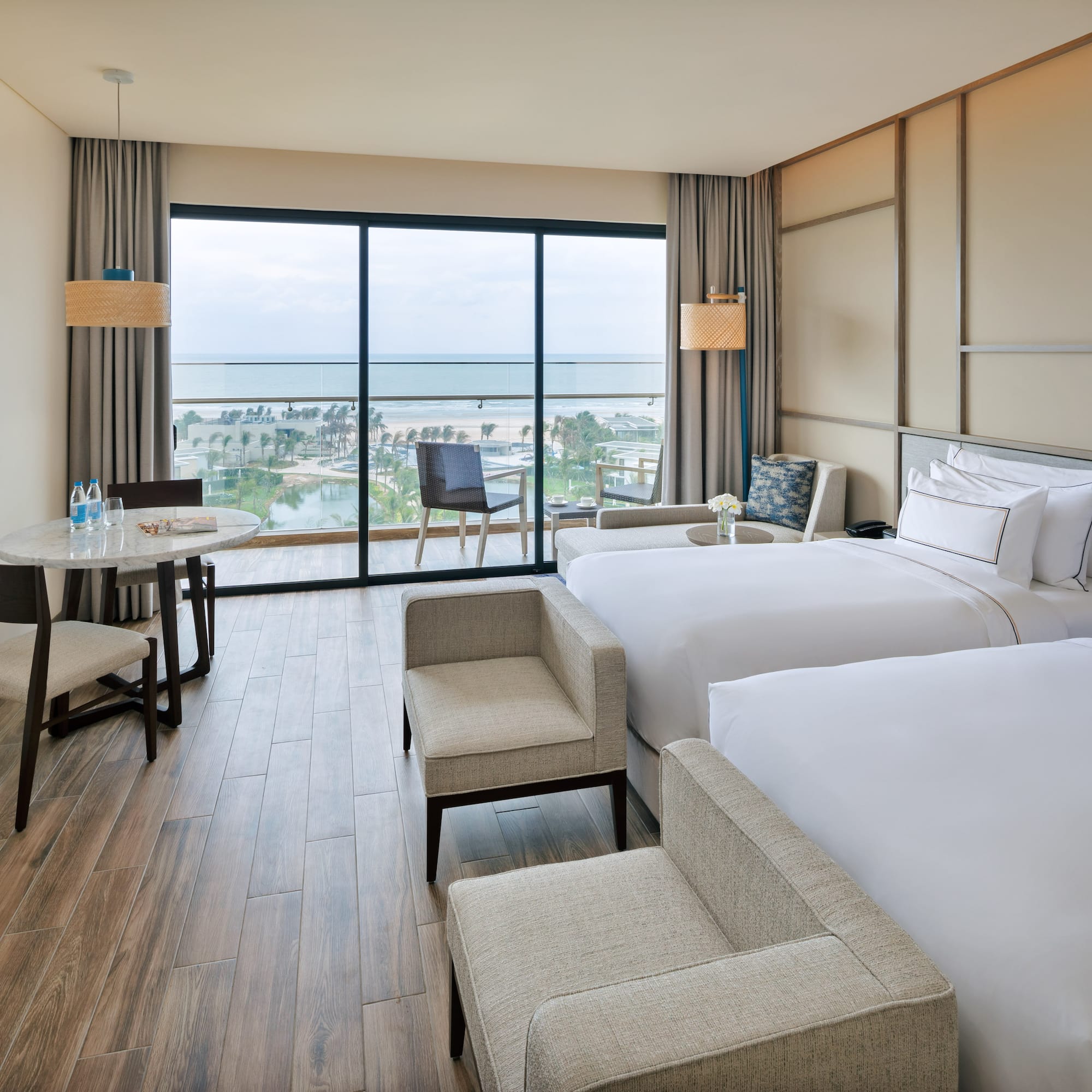 a room with two beds and a table and chairs