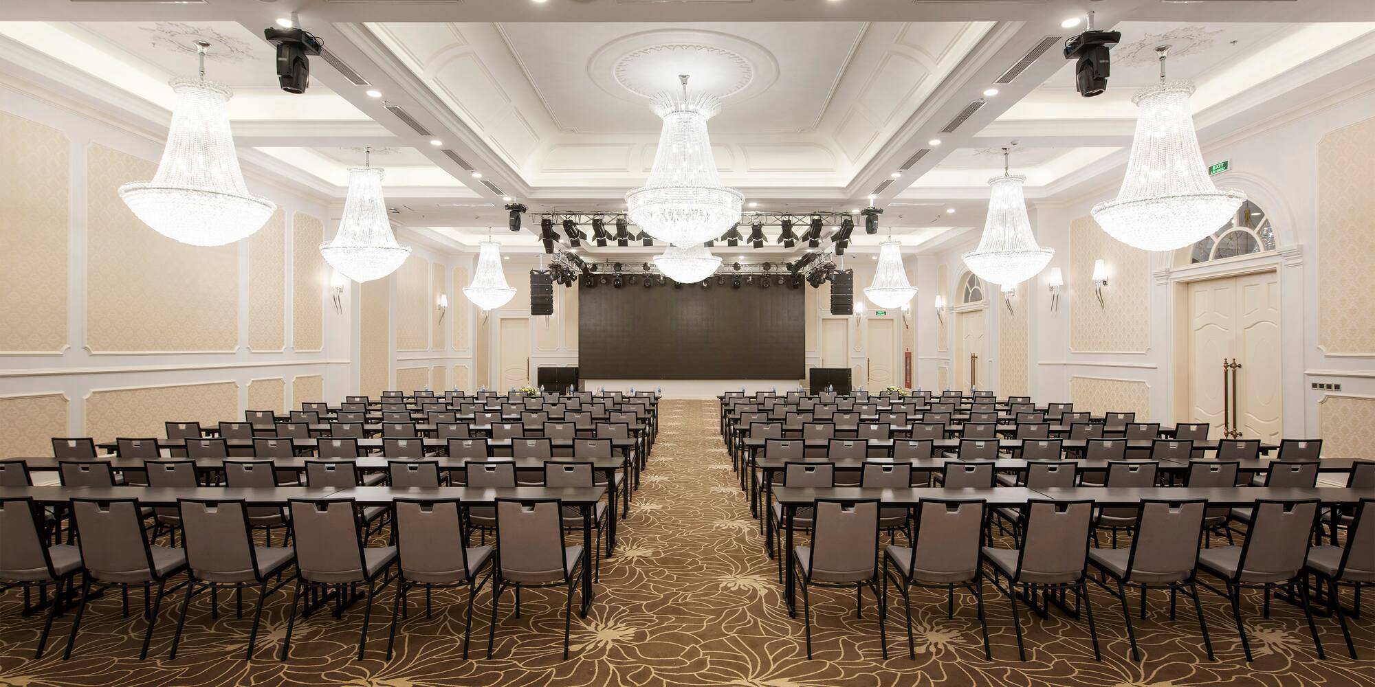 a room with chairs and chandeliers