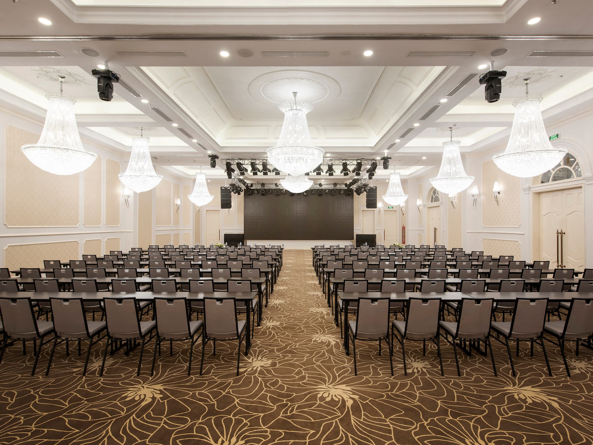a room with chairs and chandeliers