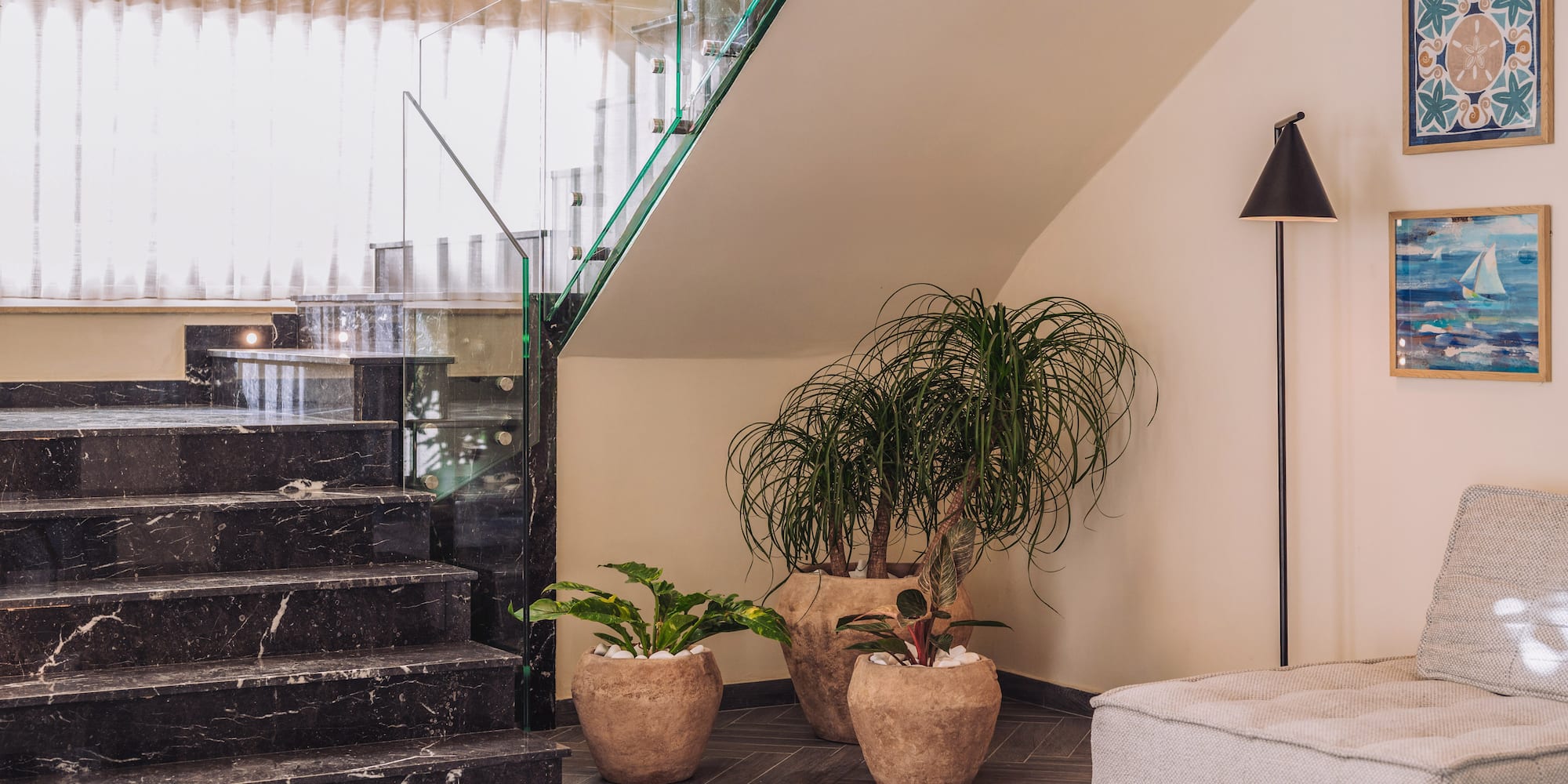 a staircase with a couch and plants in a room