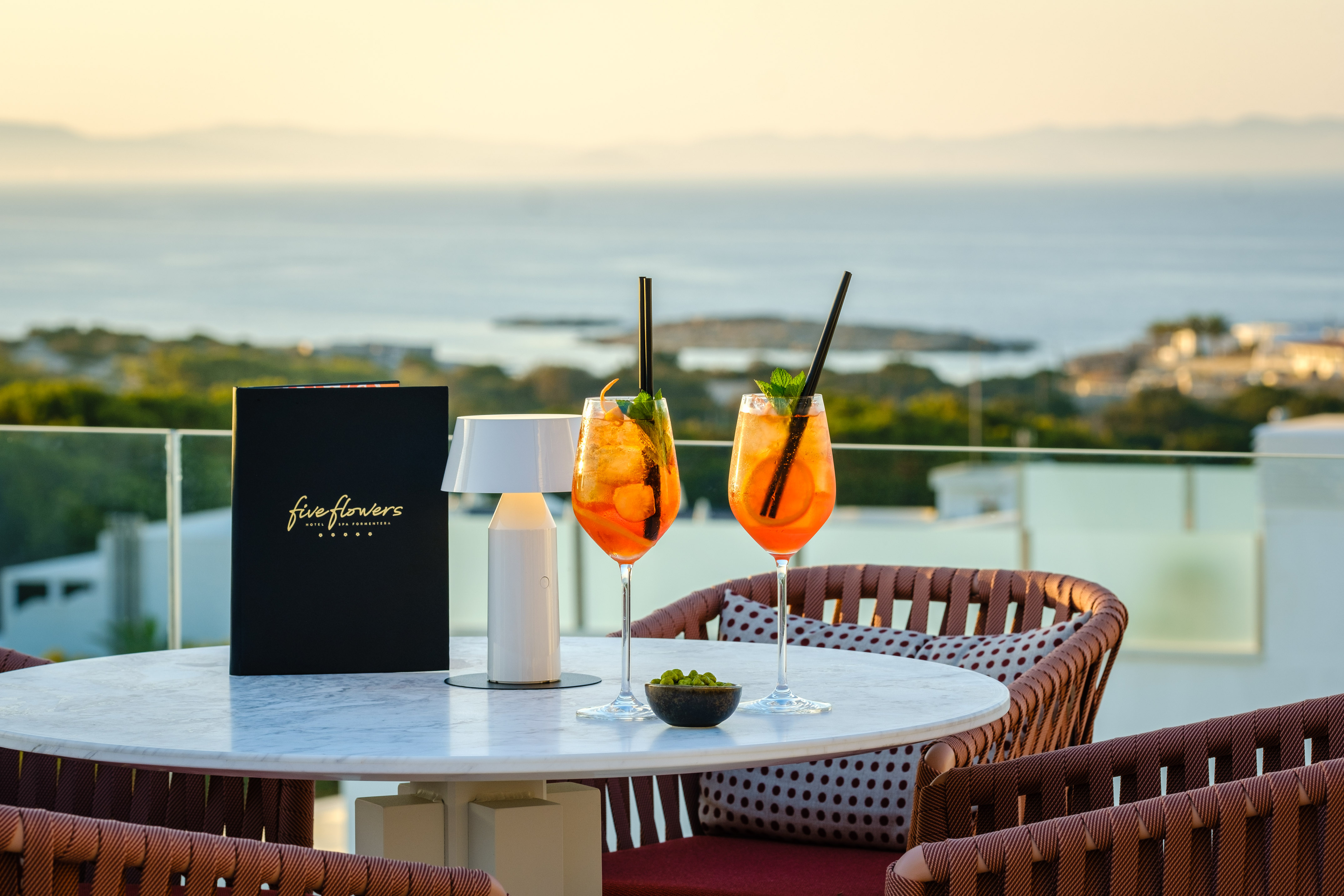 Five Flowers Hotel Formentera Aperol Spritz cocktails on terrace, sunset sea view.