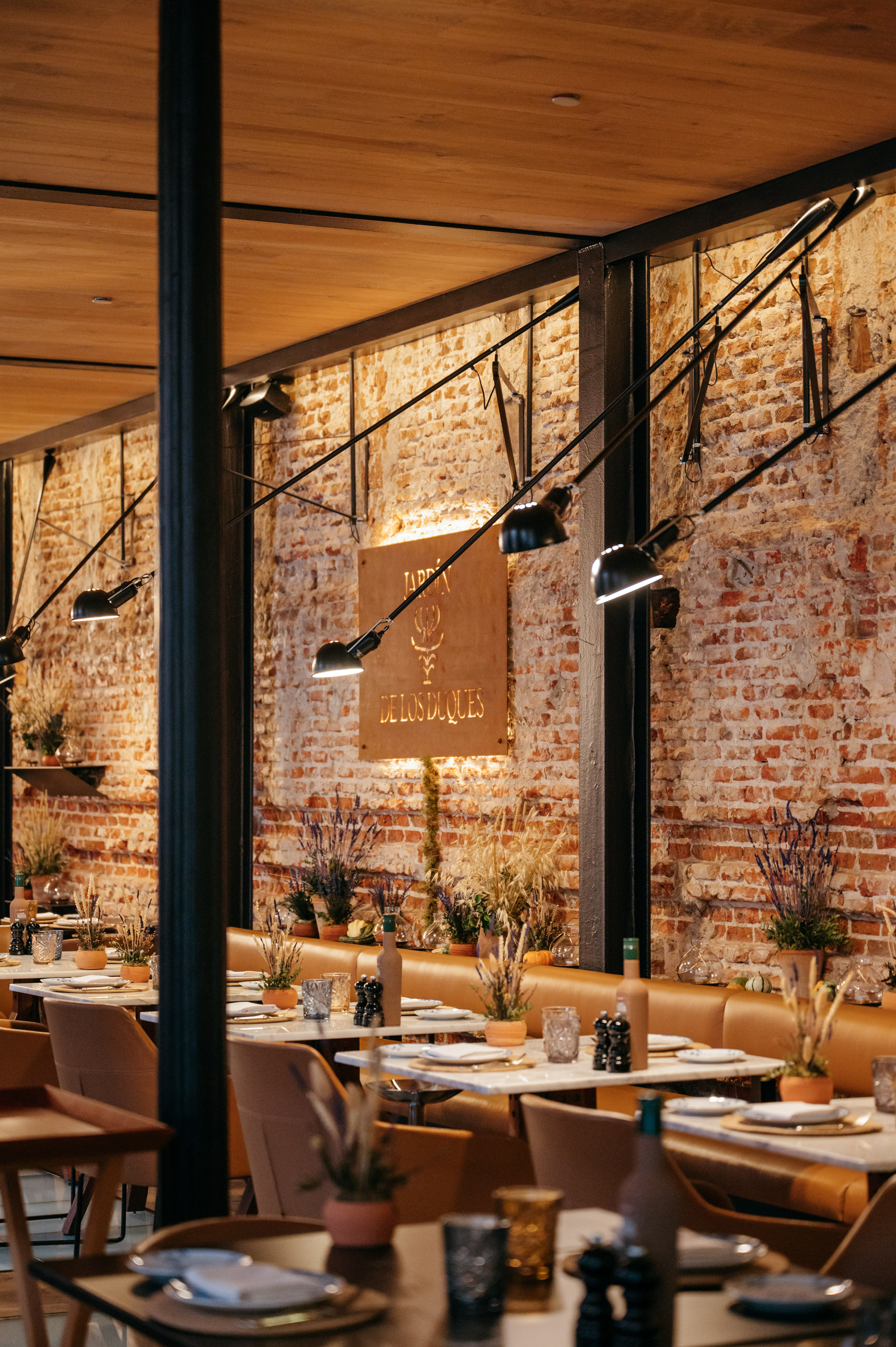 Restaurant interior: exposed brick, industrial lights, warm wood, elegant dining.