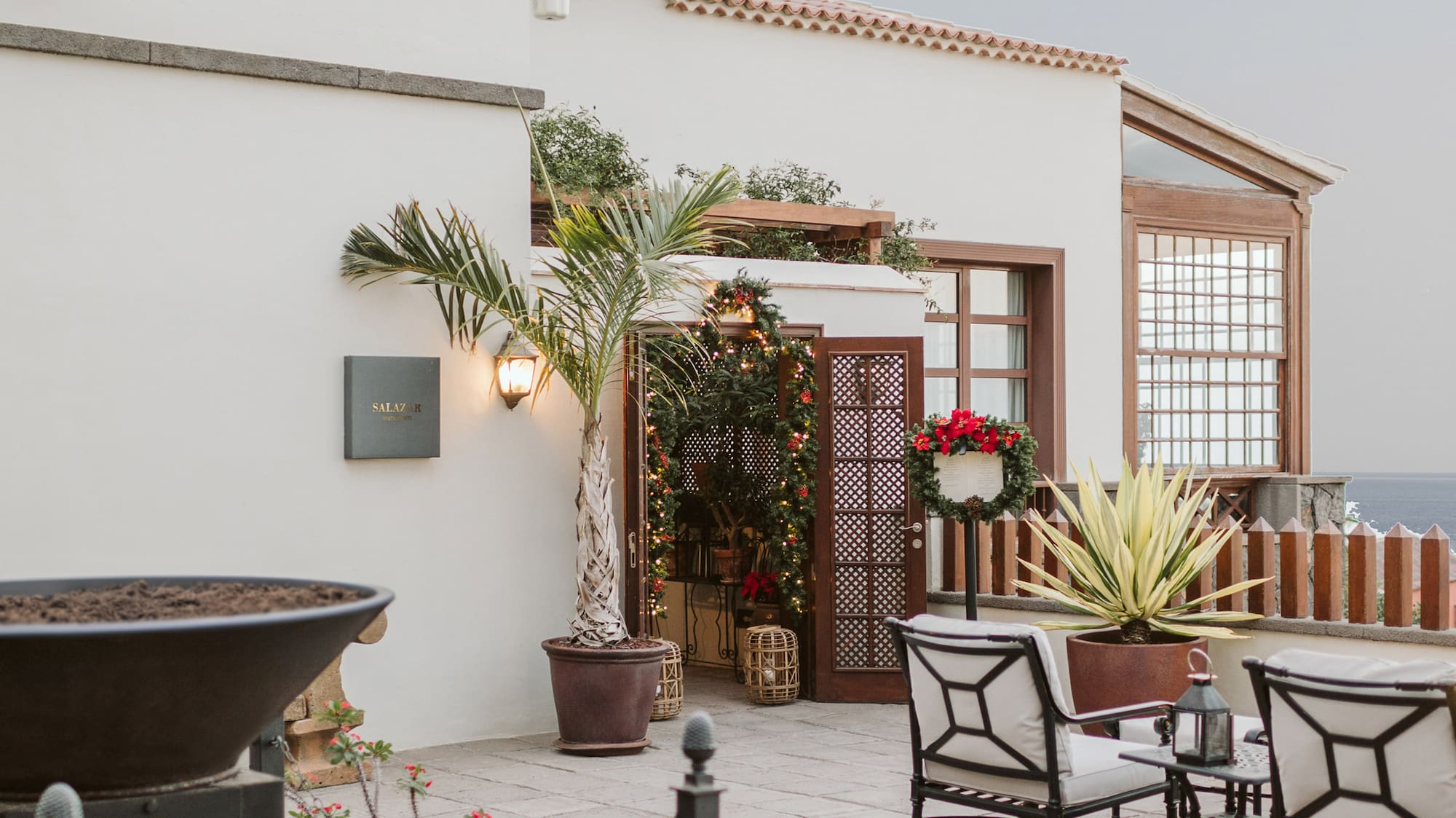 a patio with chairs and a grill on a building