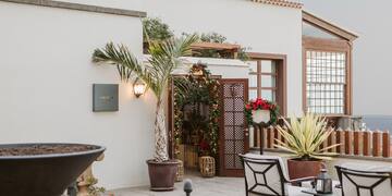 a patio with chairs and a grill on a building