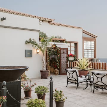 a patio with chairs and a grill on a building