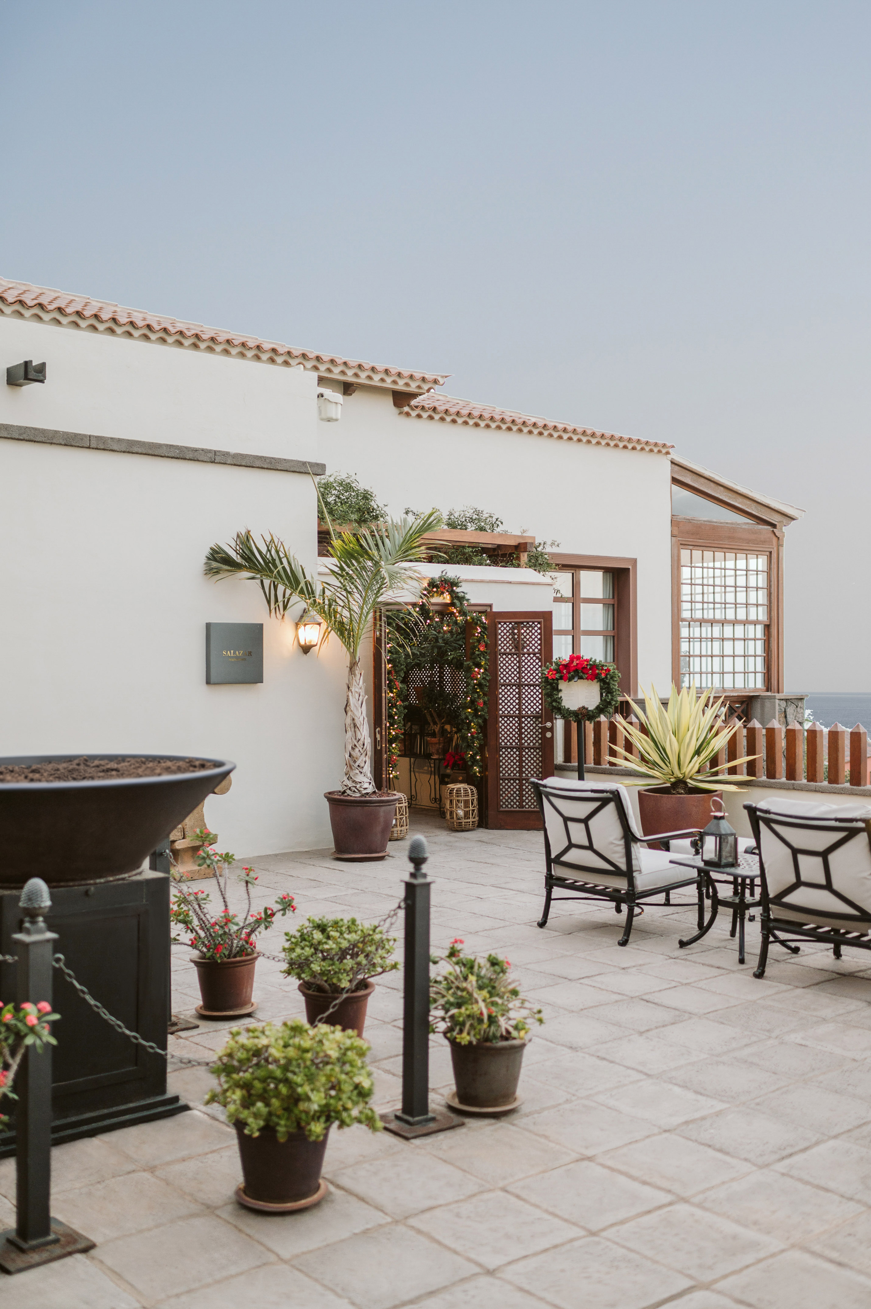 a patio with chairs and a grill on a building