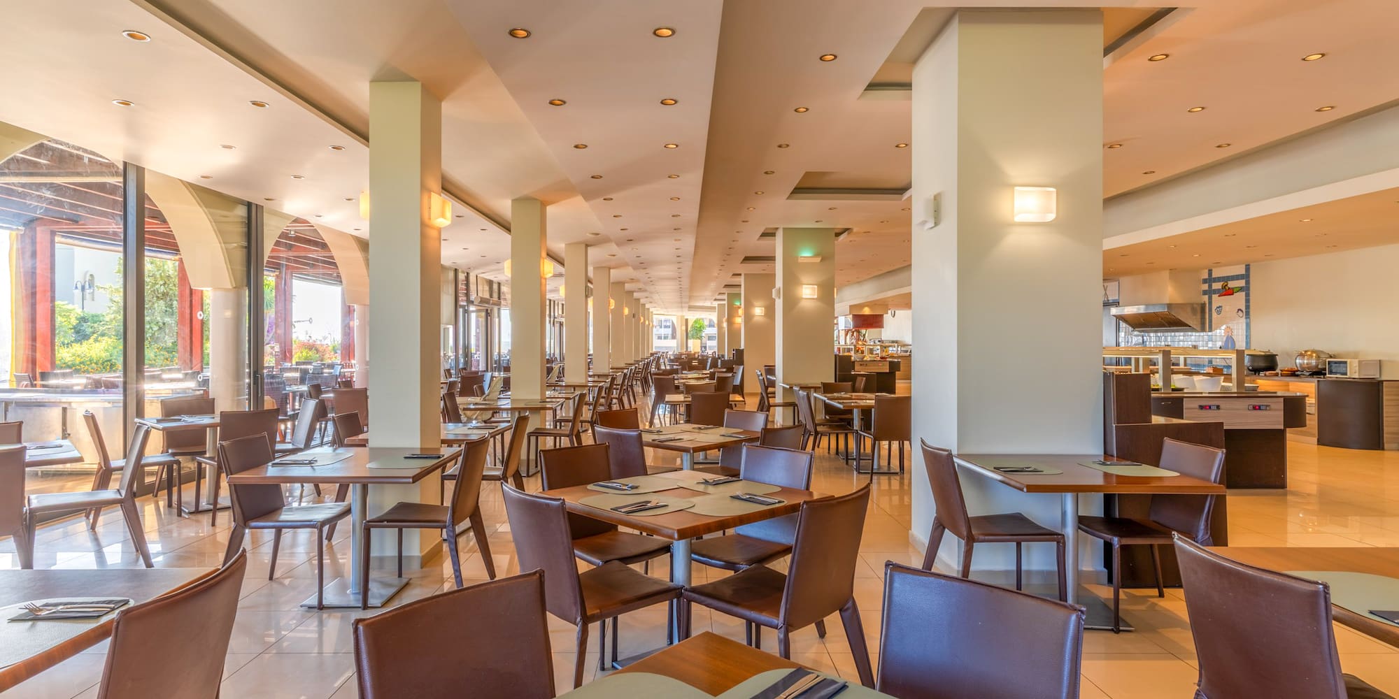 Bright hotel buffet restaurant dining room with modern tables and chairs.