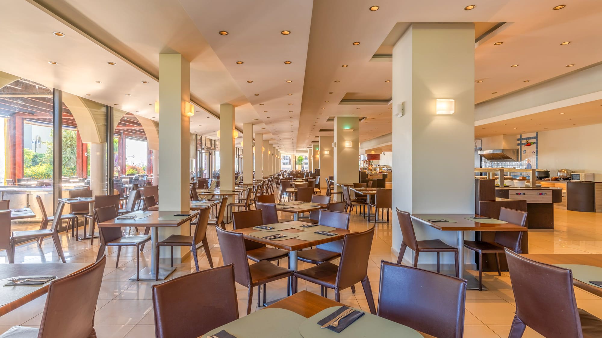 Bright hotel buffet restaurant dining room with modern tables and chairs.