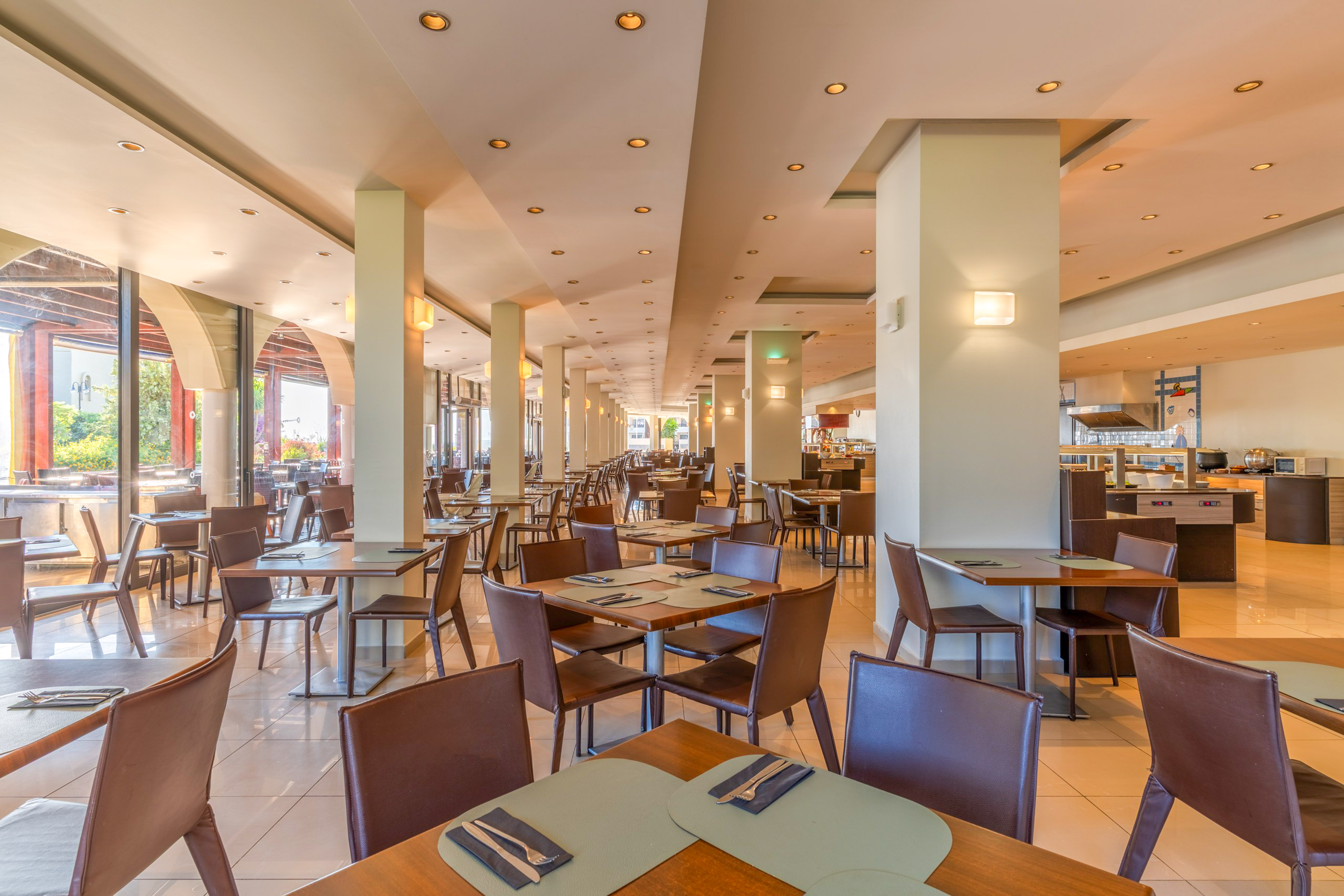 Bright hotel buffet restaurant dining room with modern tables and chairs.