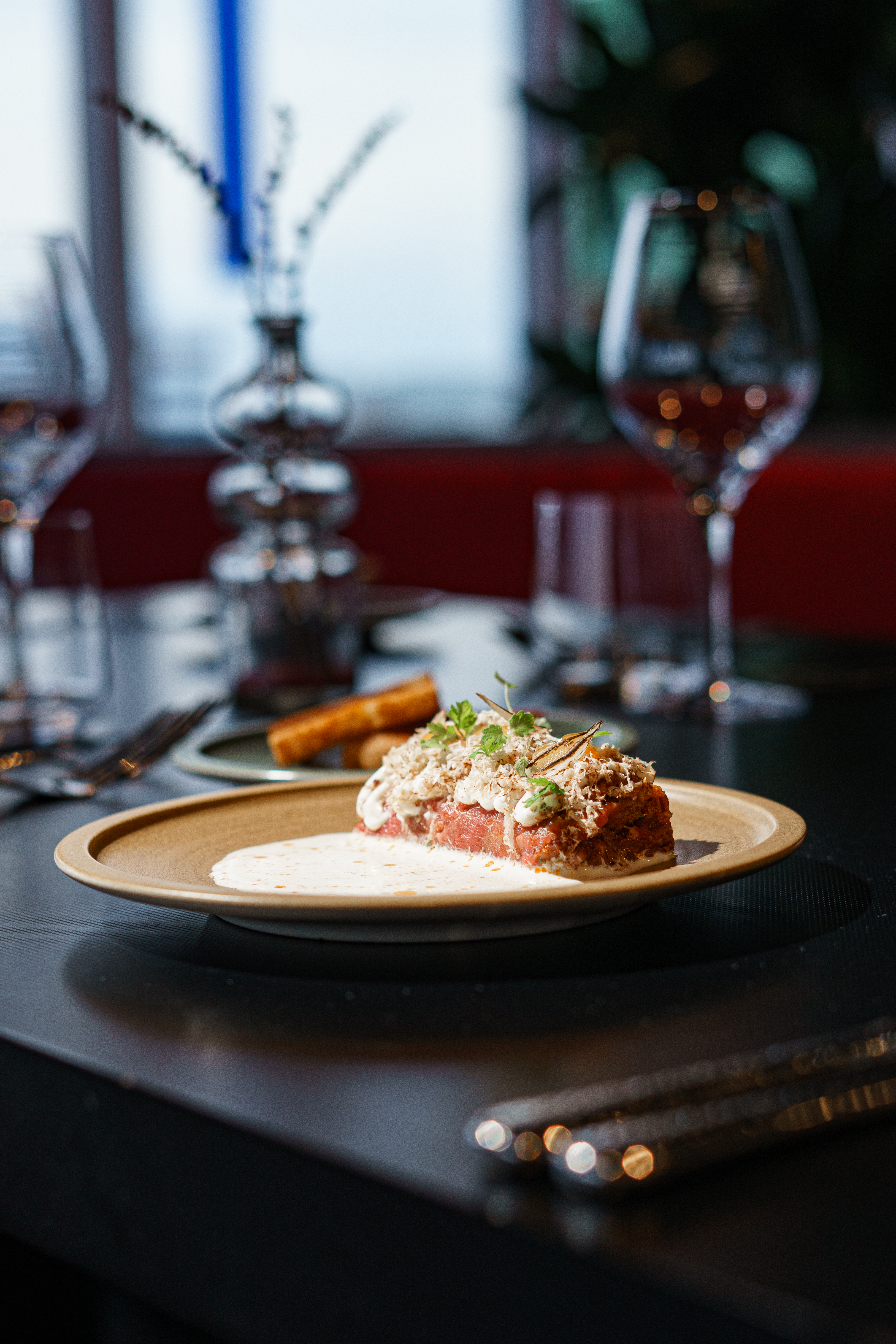 Gourmet beef tartare with truffle shavings, cream sauce, and toast points.