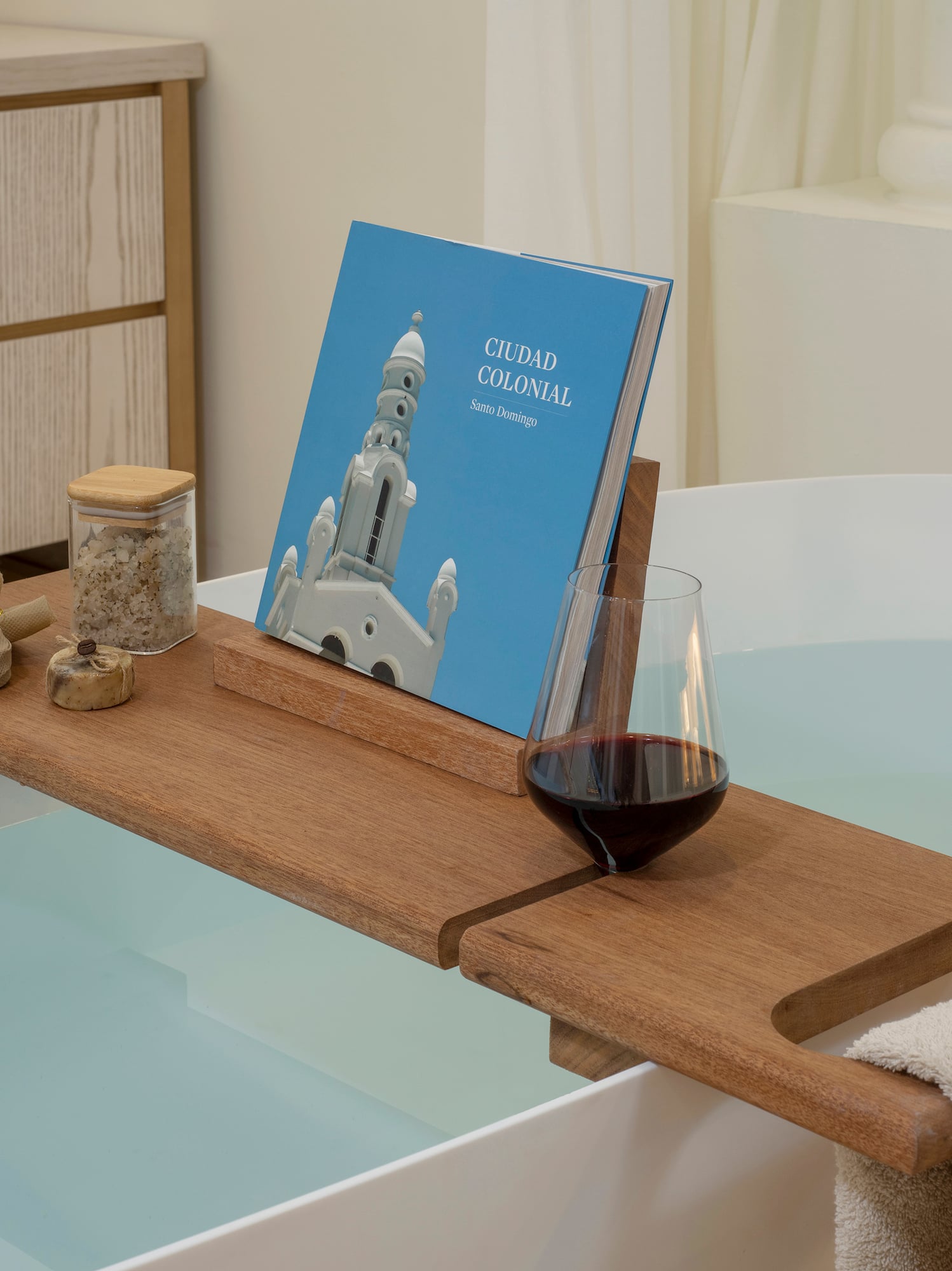 a bathtub with a book and a glass of wine