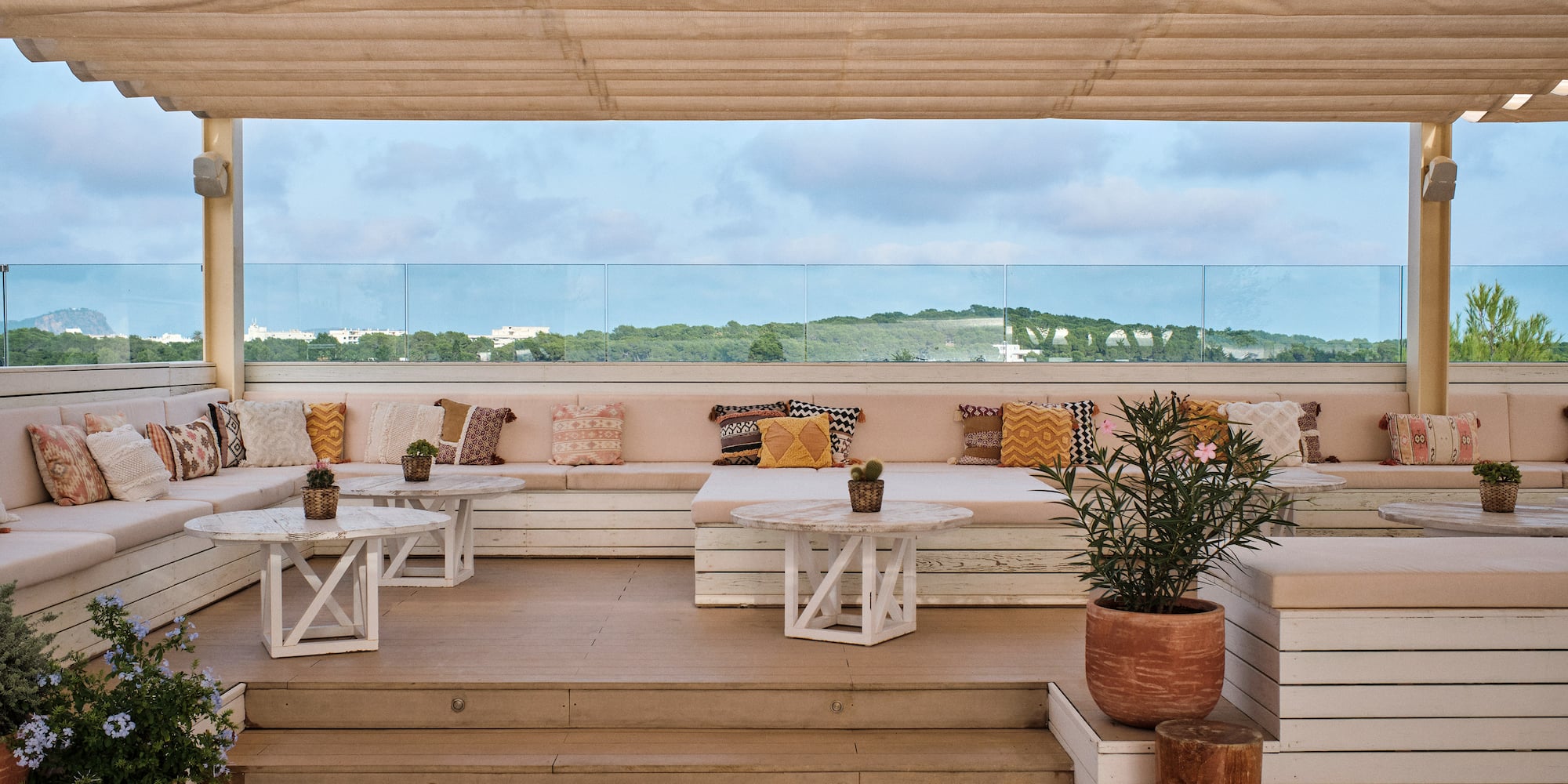 a patio with white tables and plants