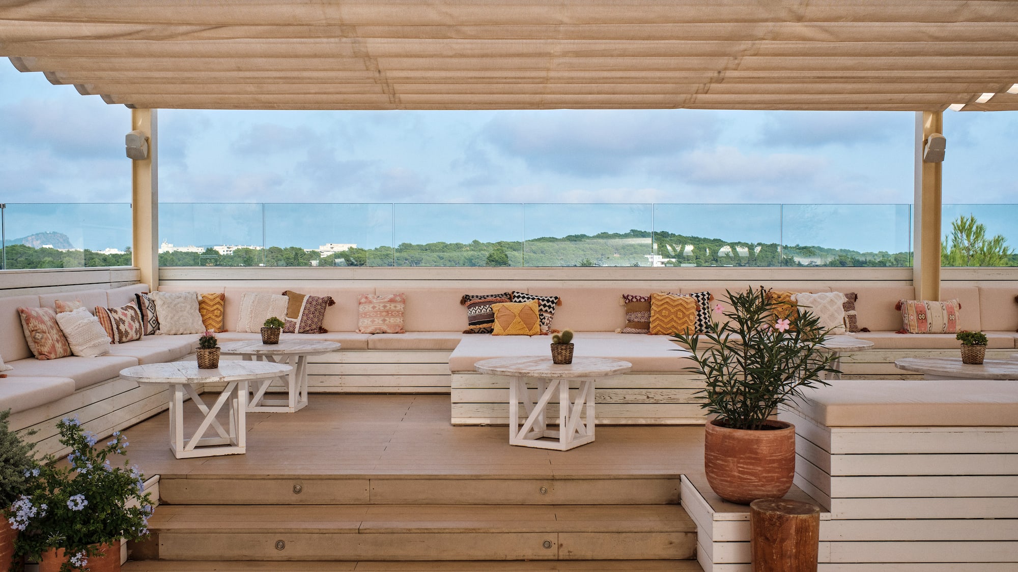 a patio with white tables and plants