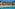 a beach with trees and buildings in the background