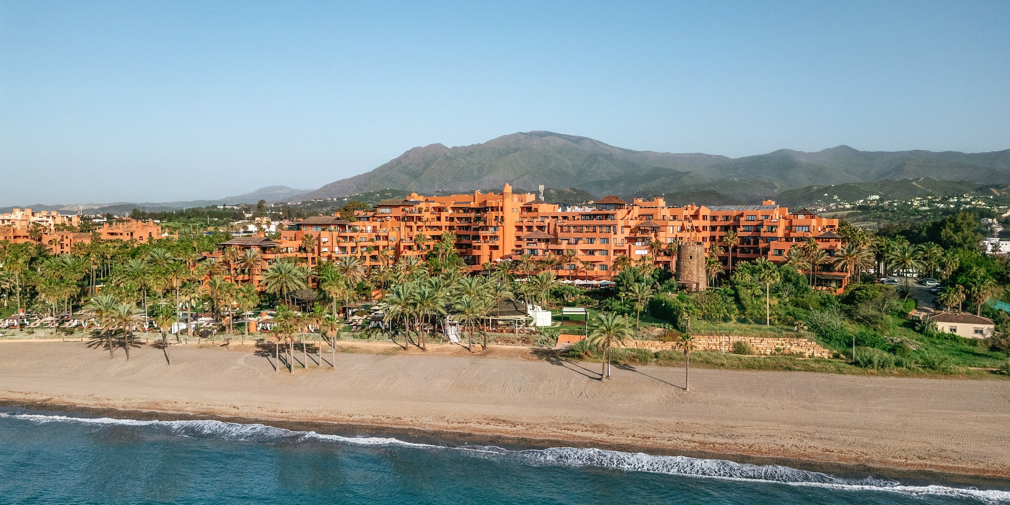 an aerial view of a resort with swimming pools and lawns