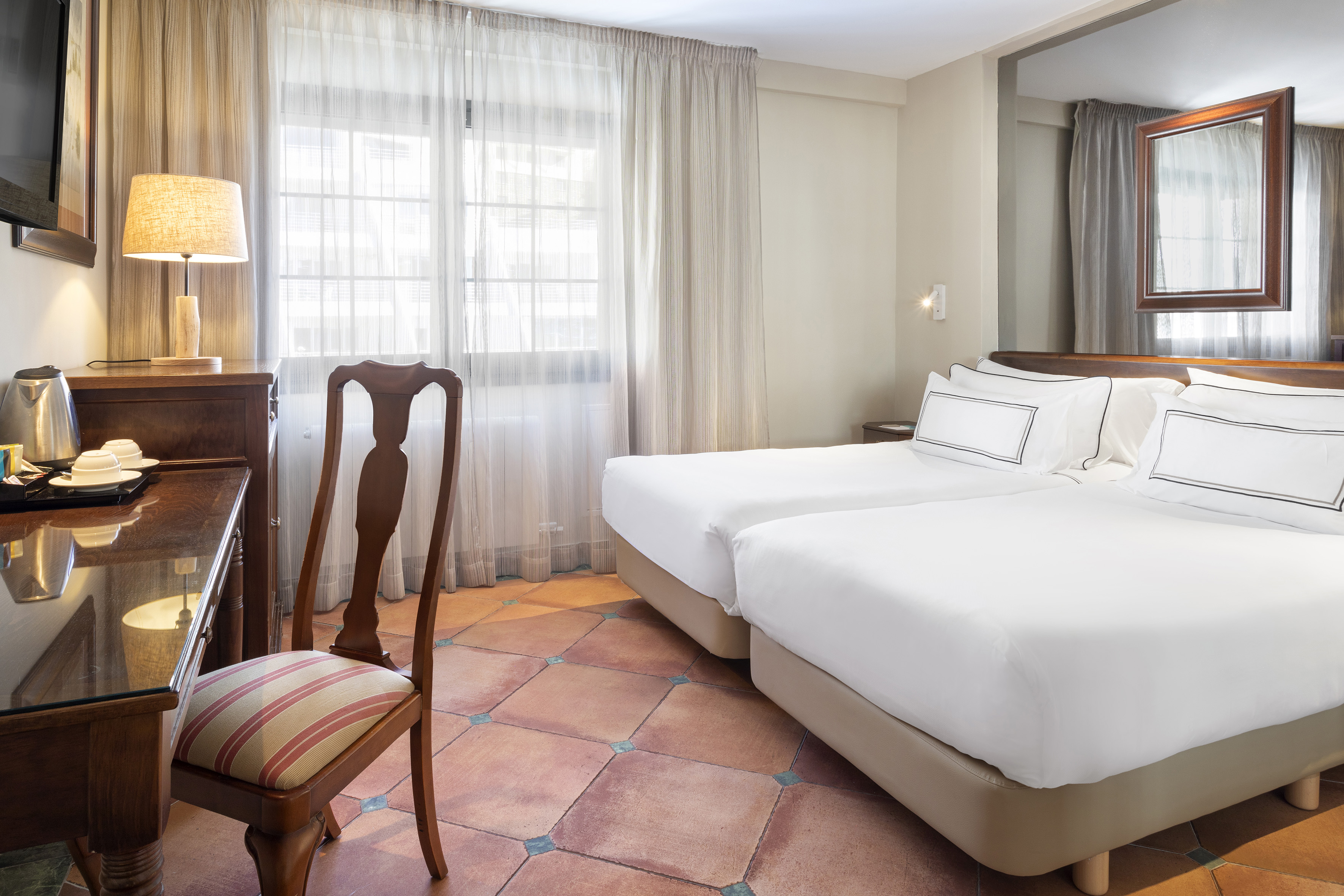 a room with two beds and a desk
